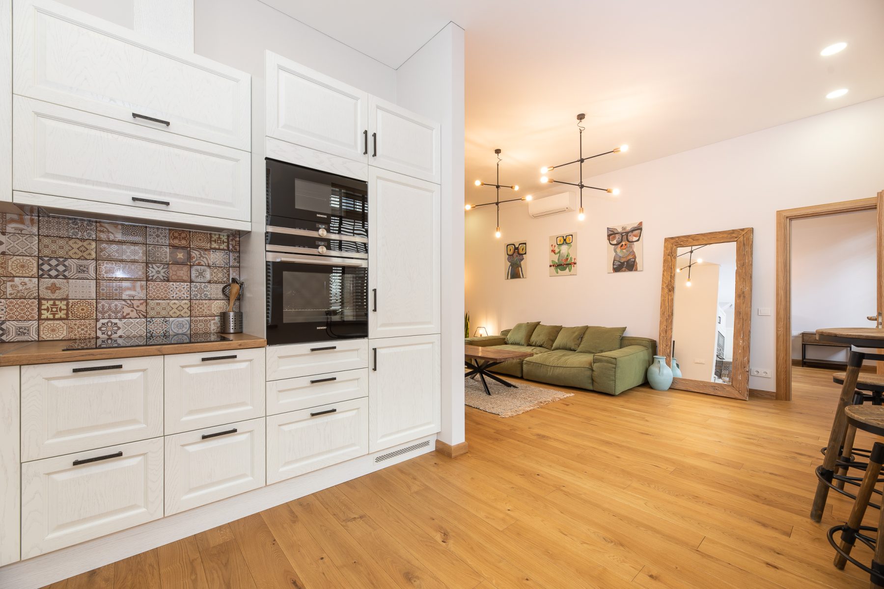 Erdvi svetainės, virtuvės ir valgomojo zona moderniame bute