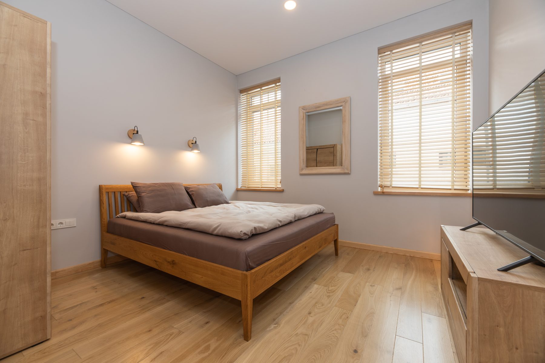 Šviesus miegamasis su moderniu dizainu ir patogia lova