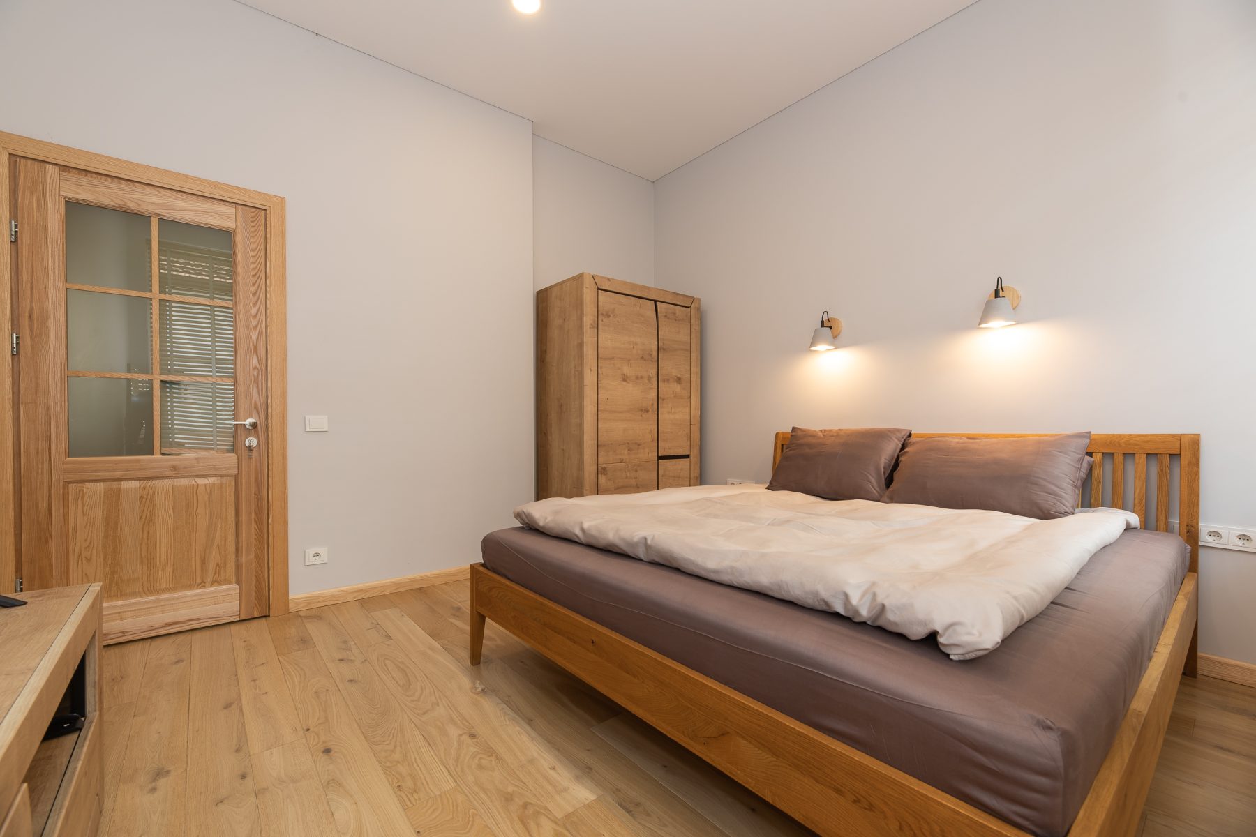 Šviesus miegamasis su moderniu dizainu ir patogia lova