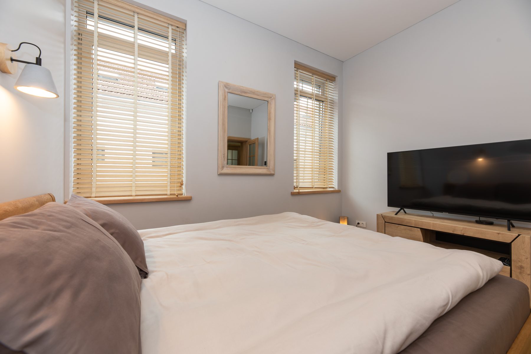 Šviesus miegamasis su moderniu dizainu ir patogia lova