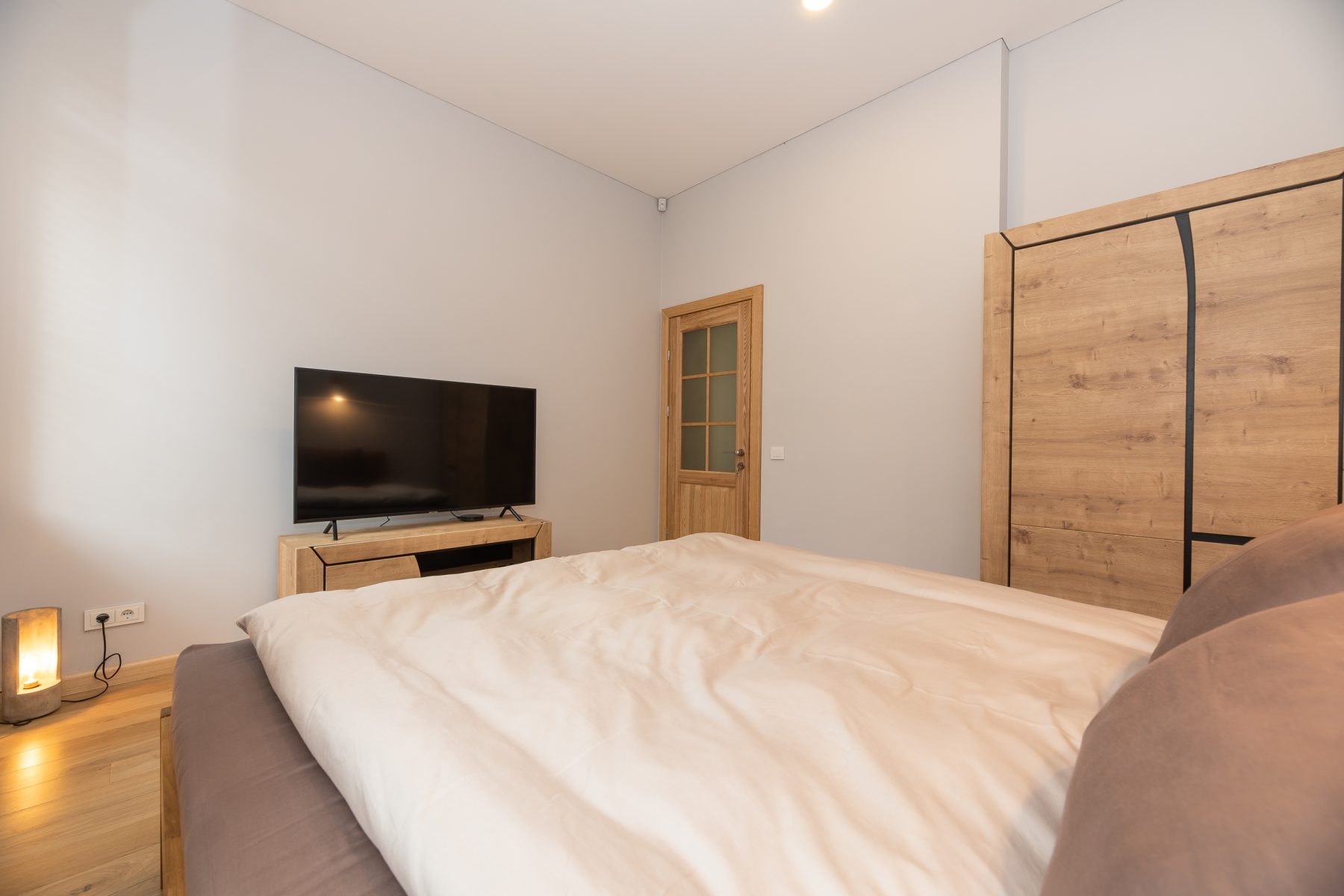 Šviesus miegamasis su moderniu dizainu ir patogia lova