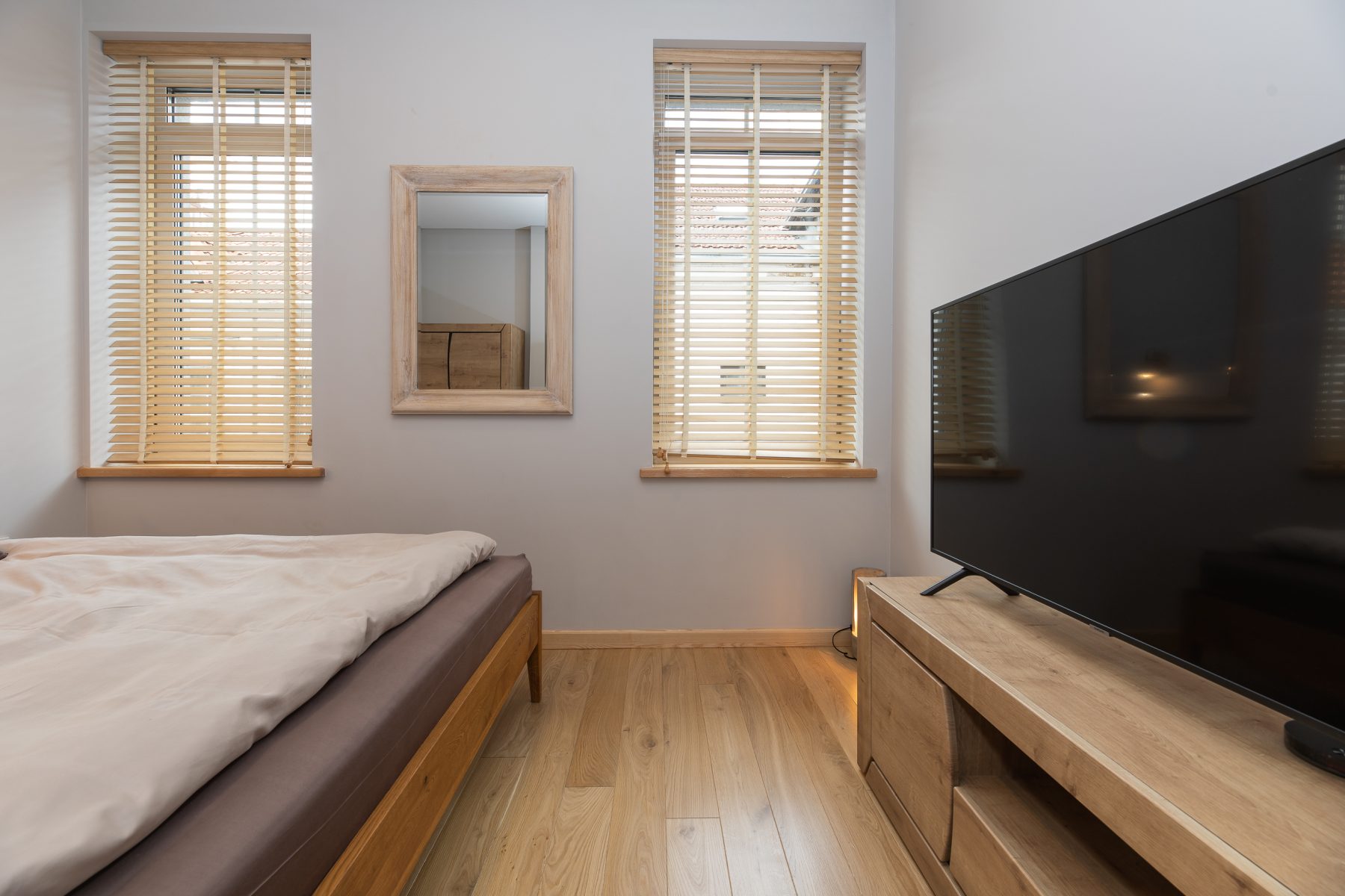 Jaukus miegamasis su patogia lova ir šviesiu interjeru