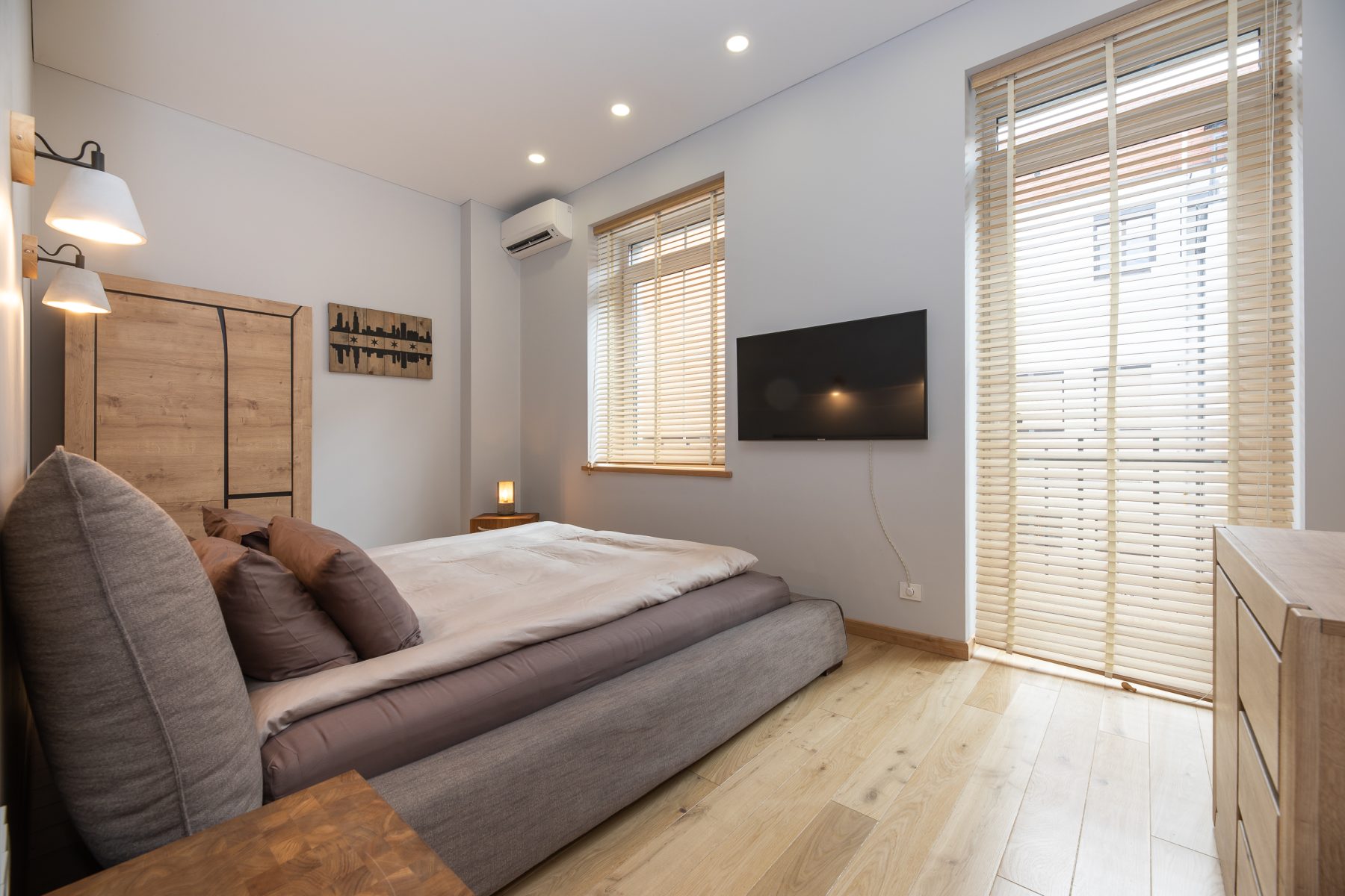 Jaukus miegamasis su patogia lova ir šviesiu interjeru