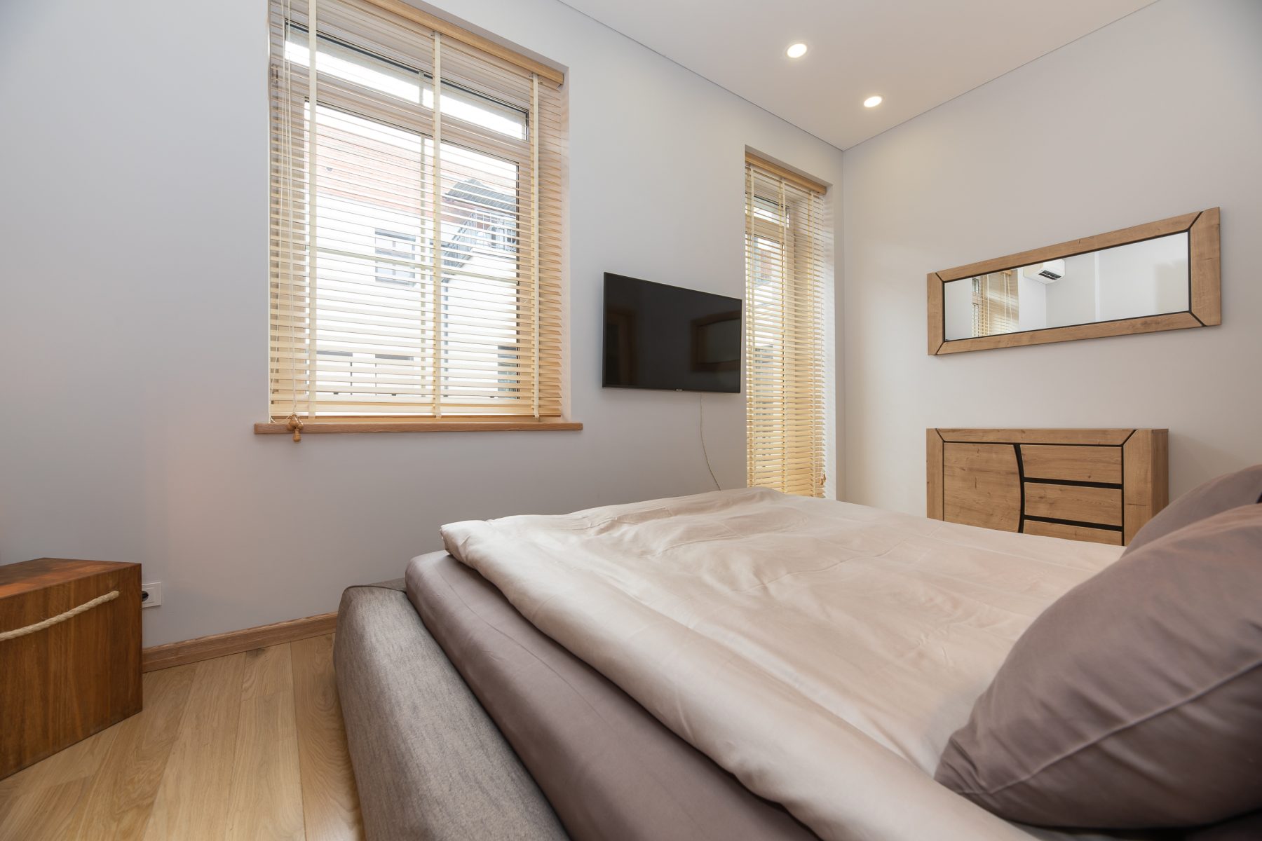 Jaukus miegamasis su patogia lova ir šviesiu interjeru