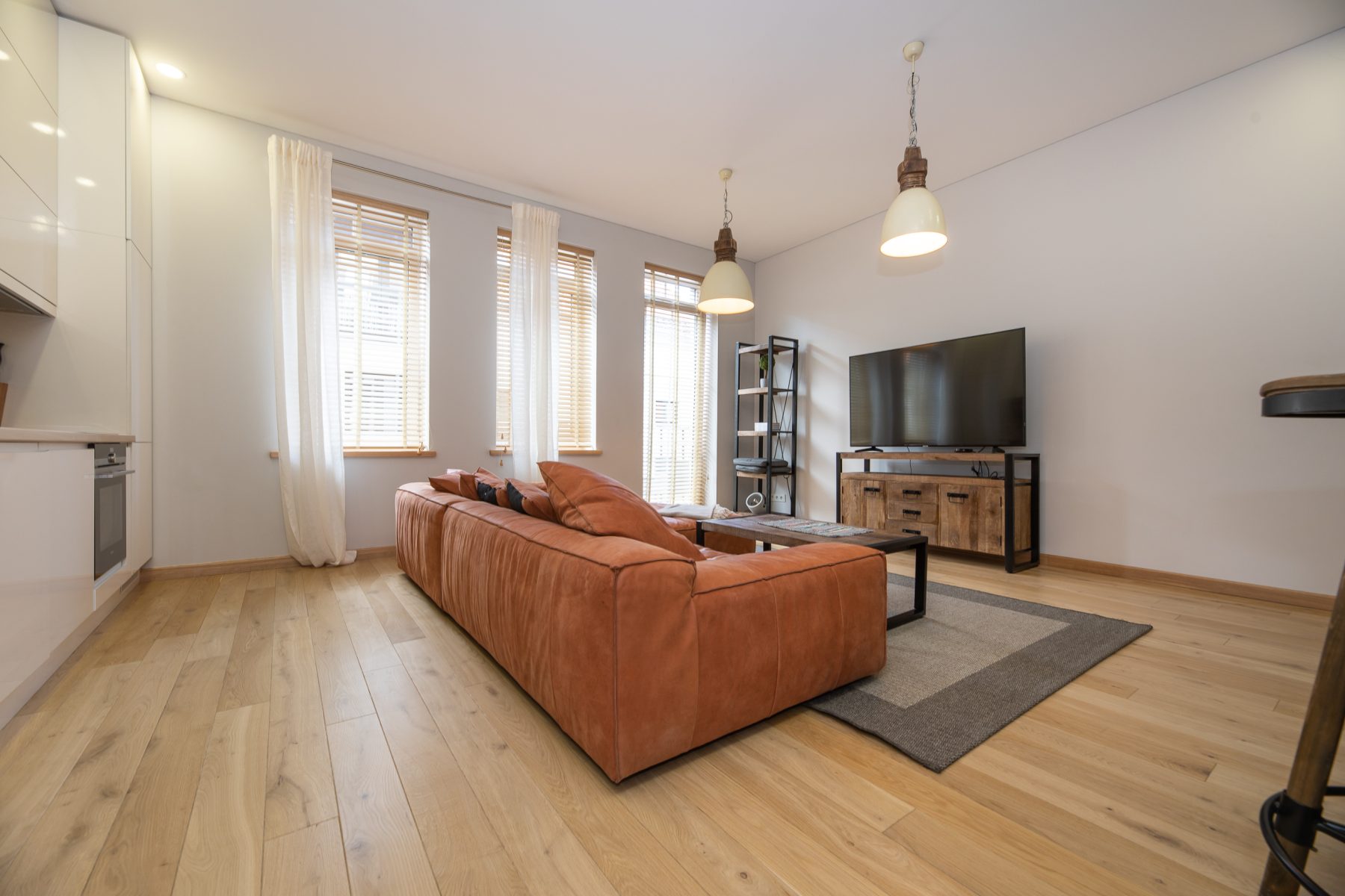 Erdvi svetainė su sofa ir moderniu interjeru