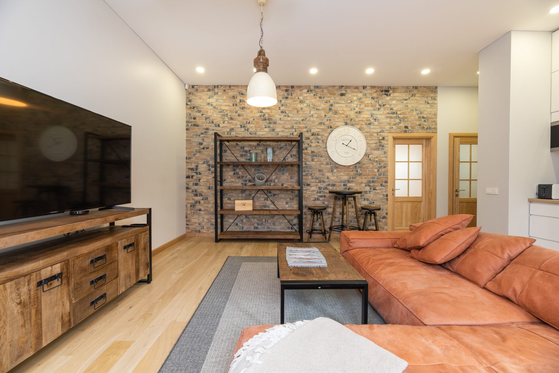 Erdvi svetainė su sofa ir moderniu interjeru