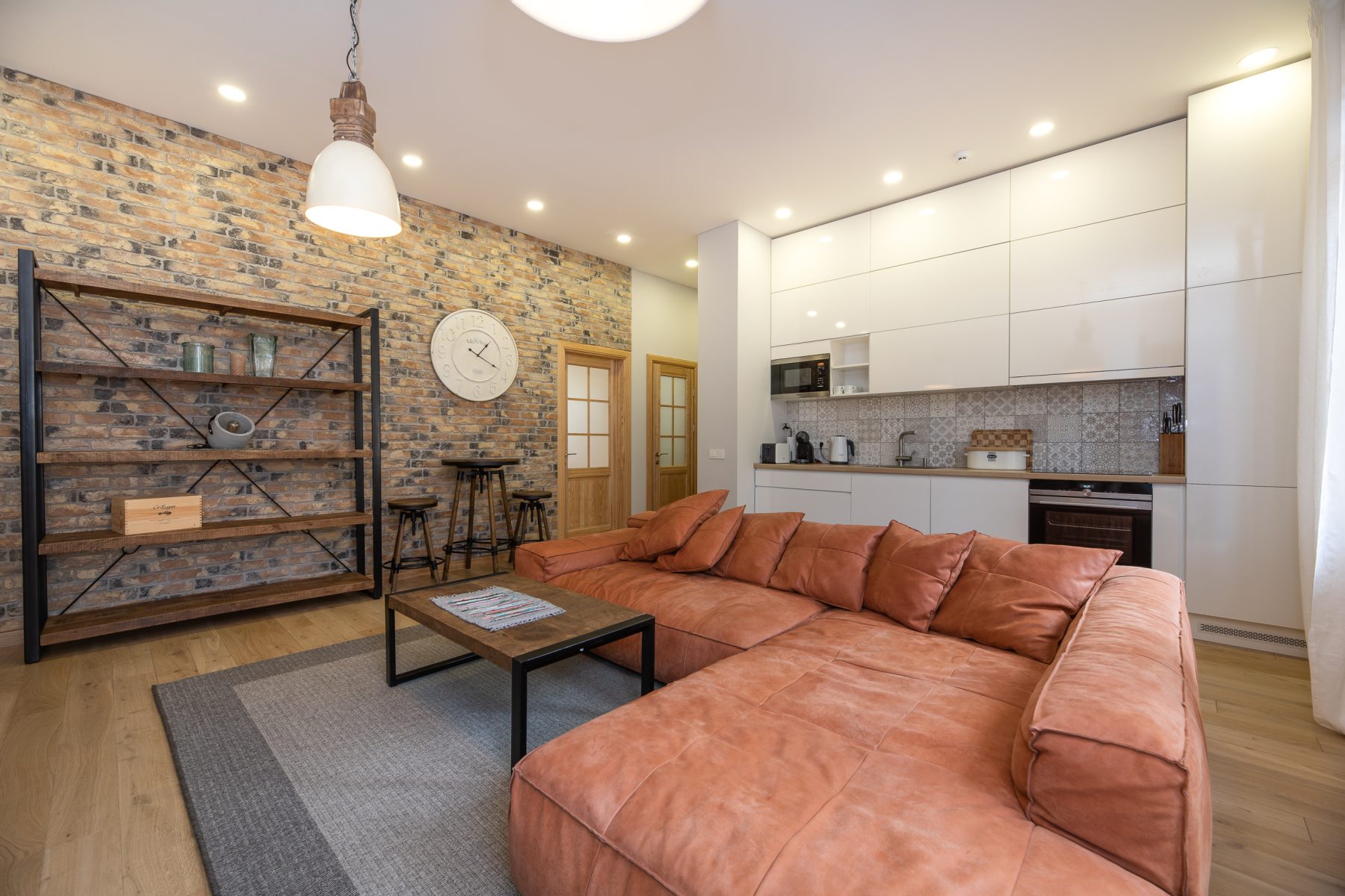 Erdvi svetainė su sofa ir moderniu interjeru