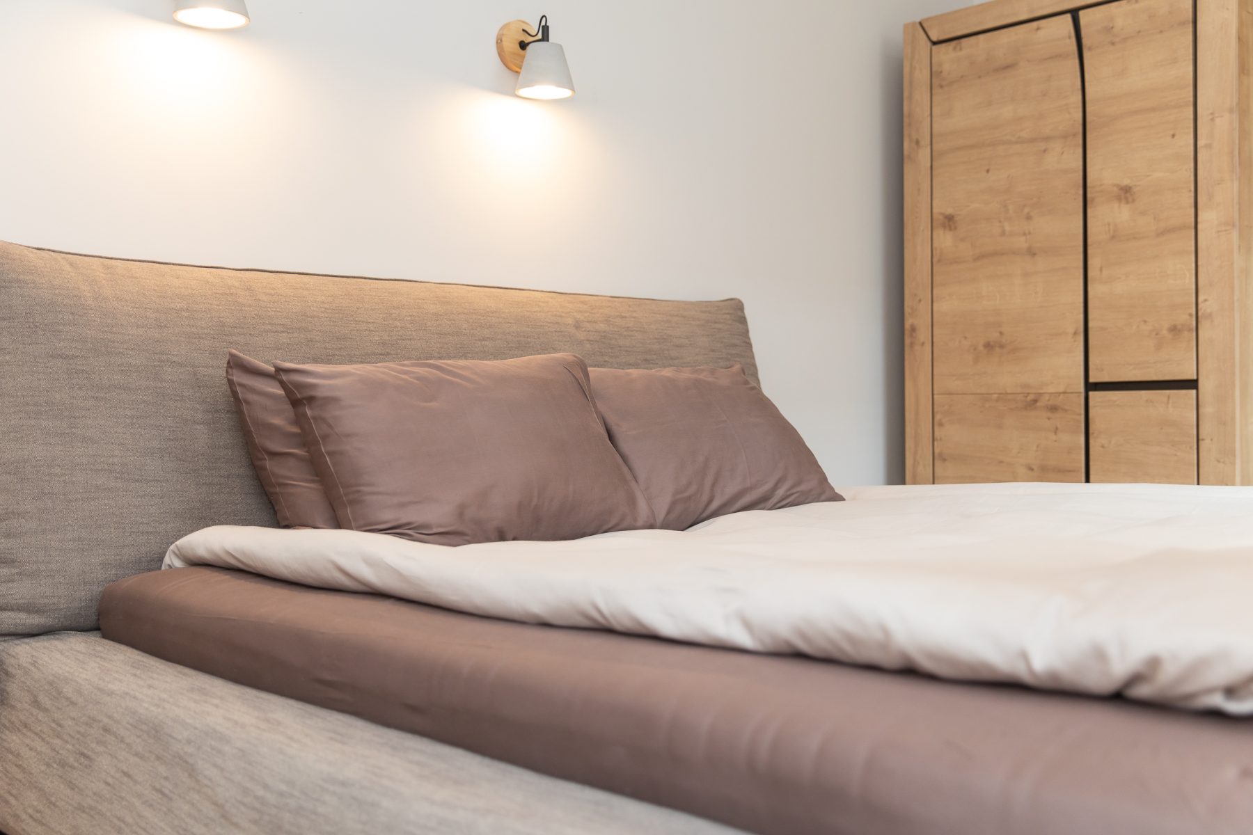 Jaukus miegamasis su patogia lova ir šviesiu interjeru