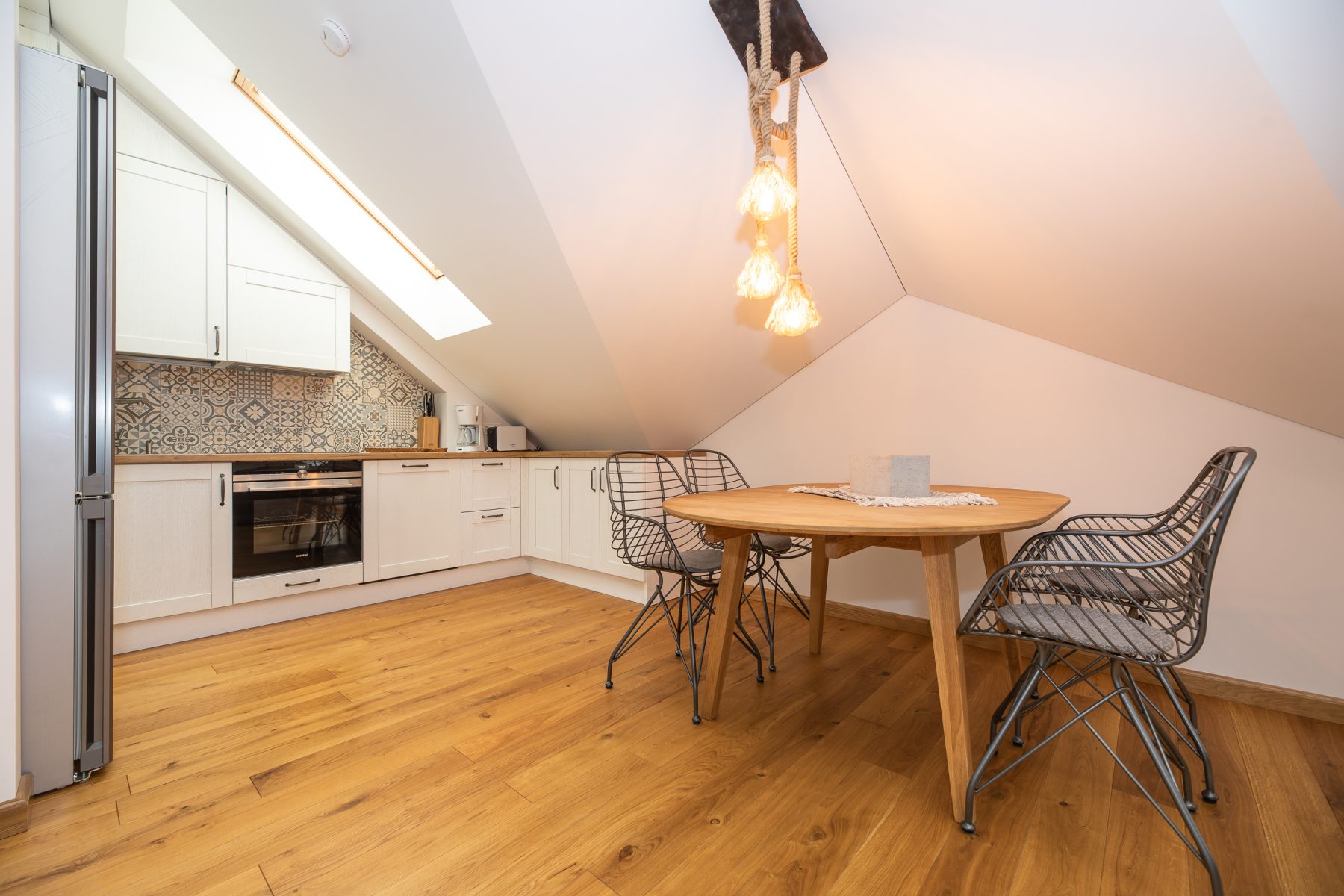 Moderni virtuvė su buitine technika ir valgomojo zona