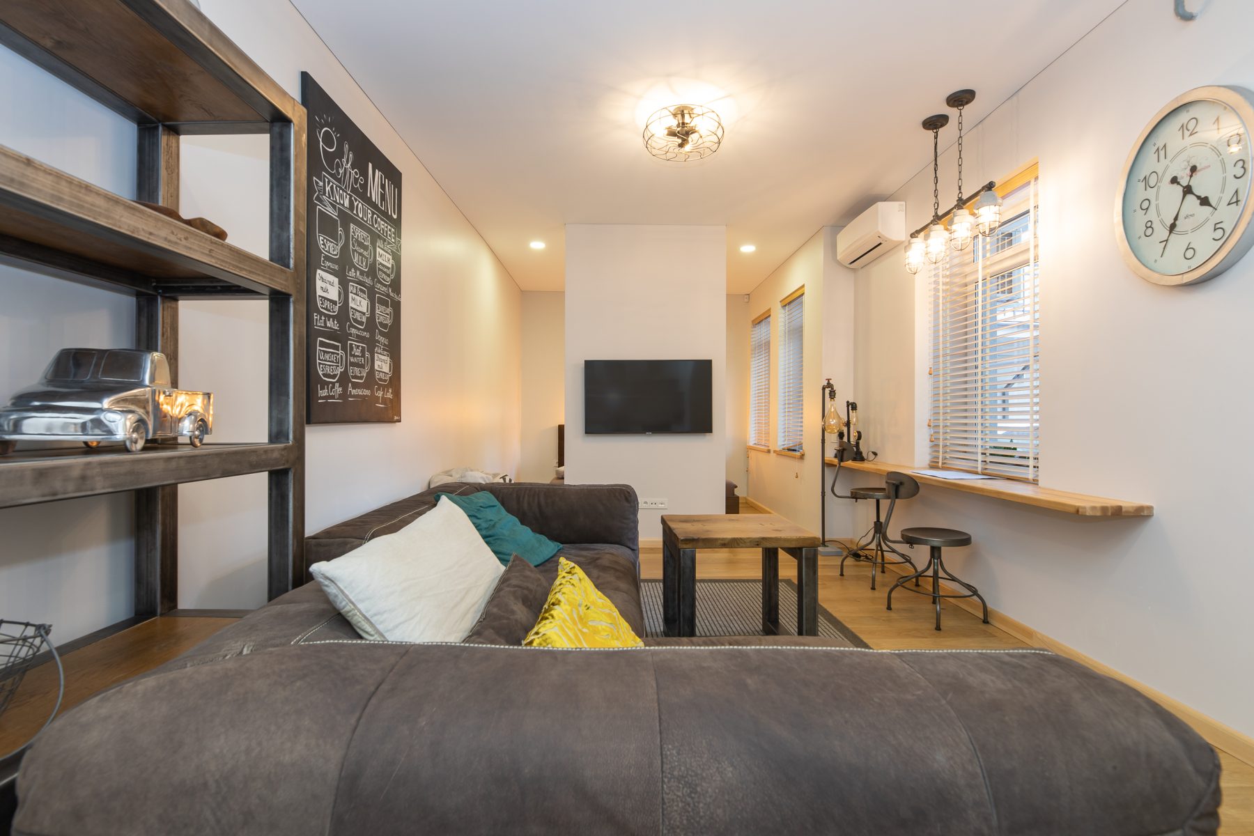 Moderni svetainė su patogia sofa ir šiuolaikišku interjeru