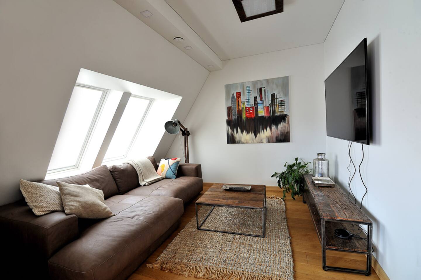 Erdvi svetainė su sofa, laiptais ir natūralia šviesa