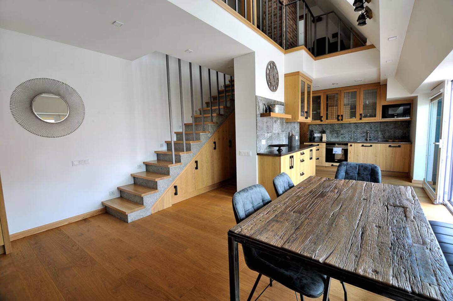 Erdvi svetainė su sofa, laiptais ir natūralia šviesa