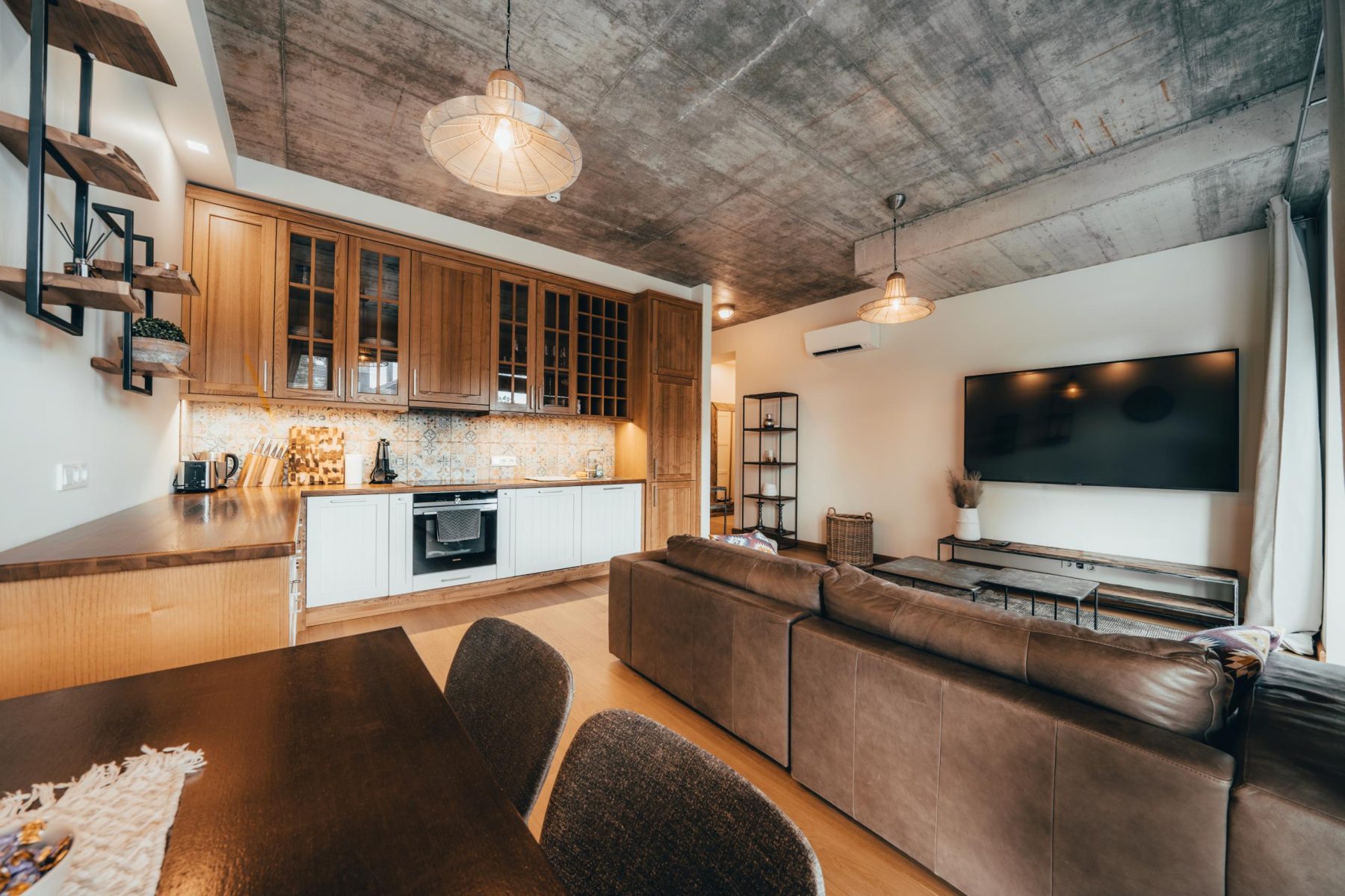 Moderni svetainė su sofa ir atvira virtuvės zona