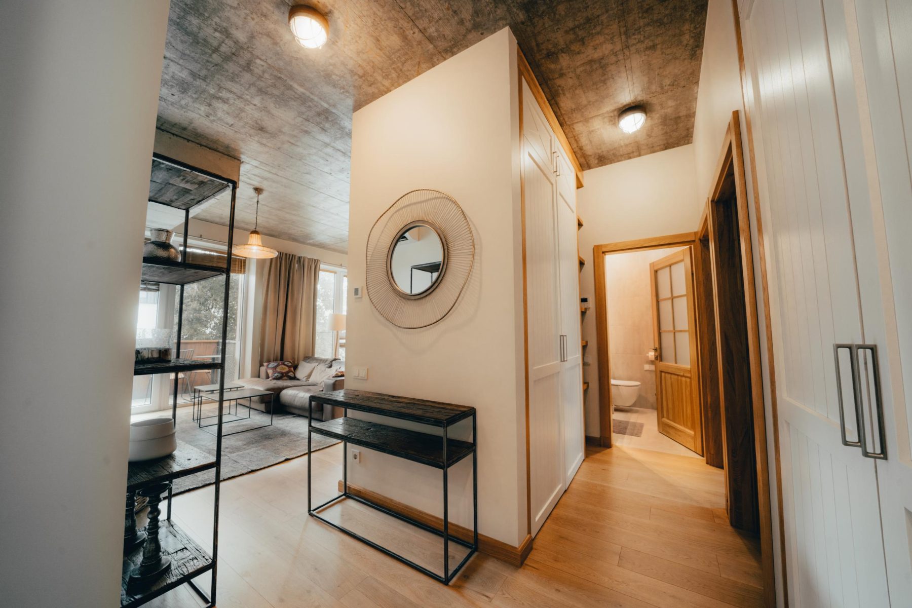 Moderni svetainė su sofa ir atvira virtuvės zona