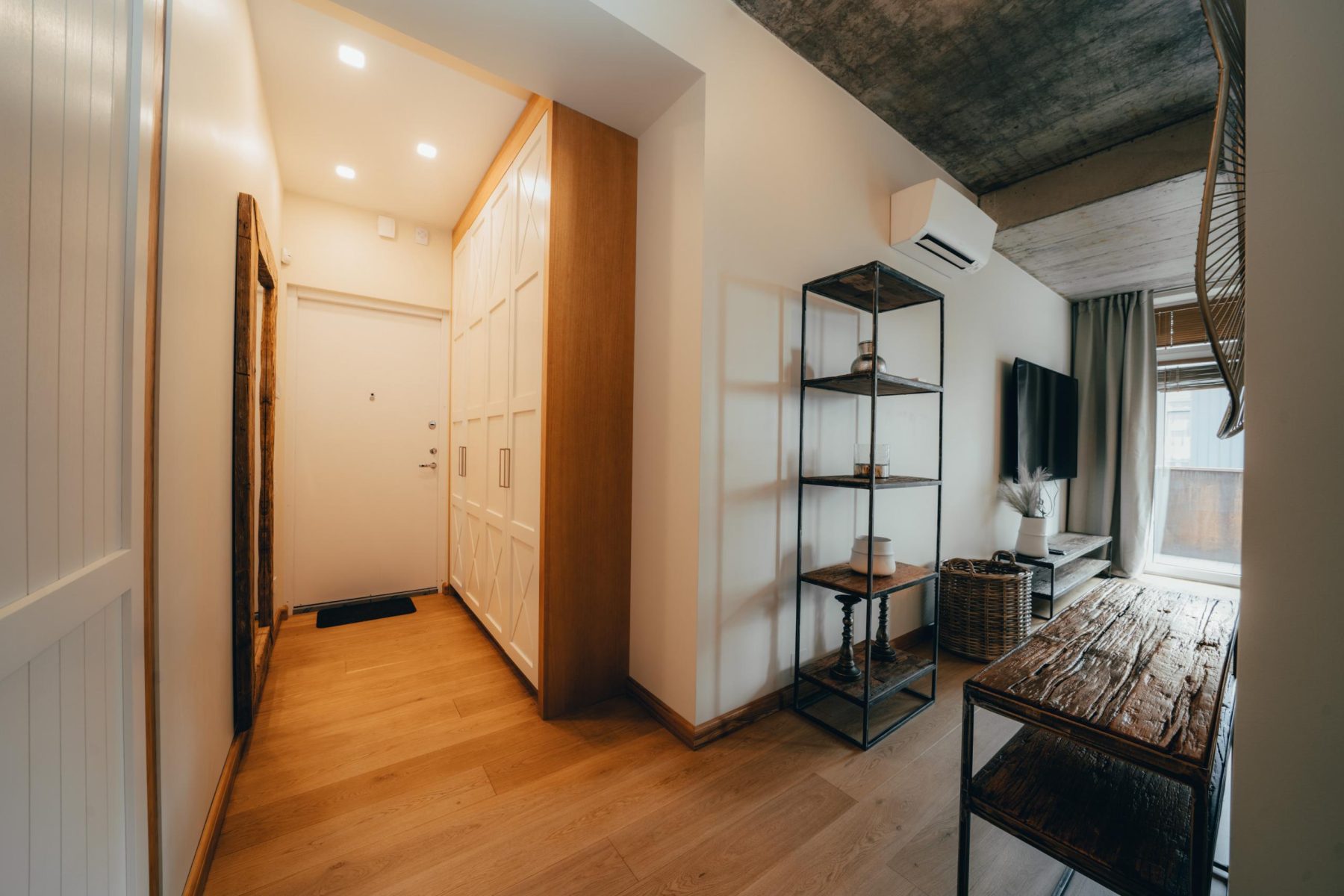 Moderni svetainė su sofa ir atvira virtuvės zona