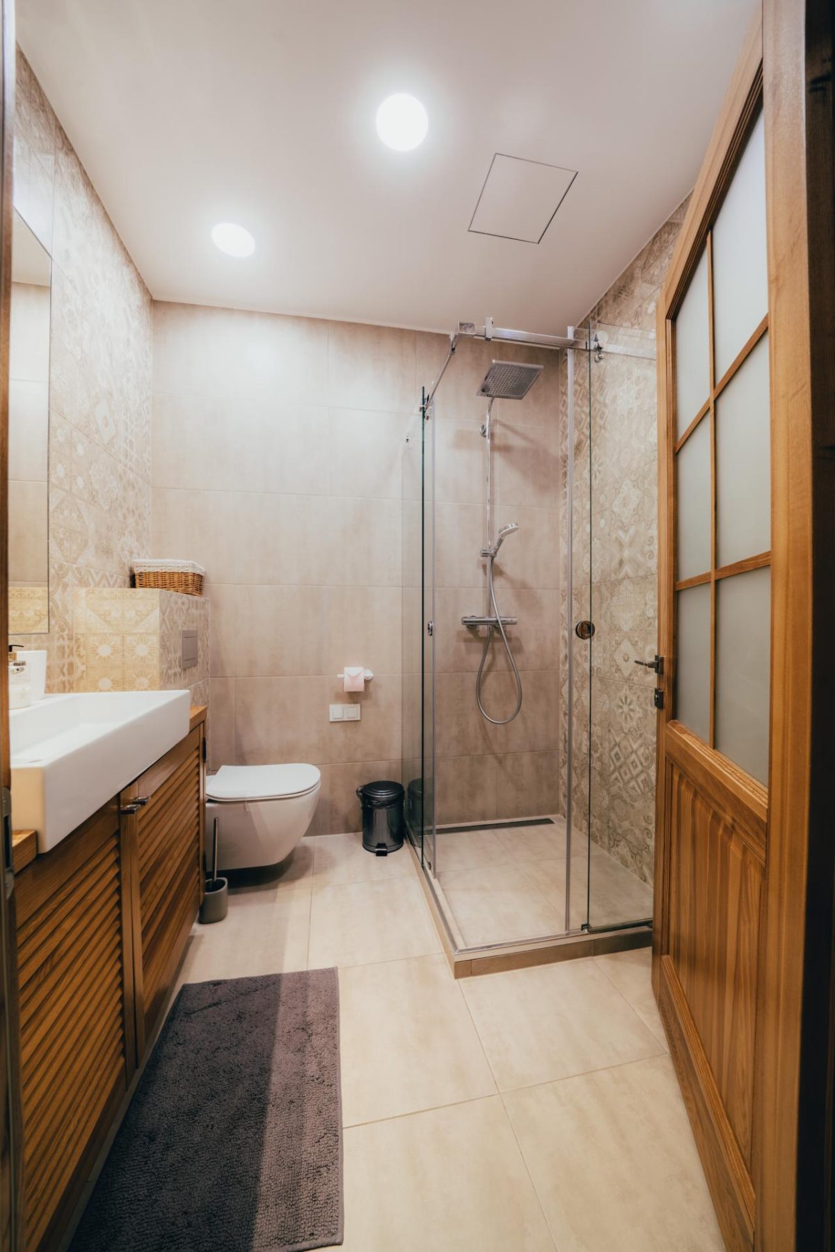 Modernus vonios kambarys su dušu ir šviesia apdaila