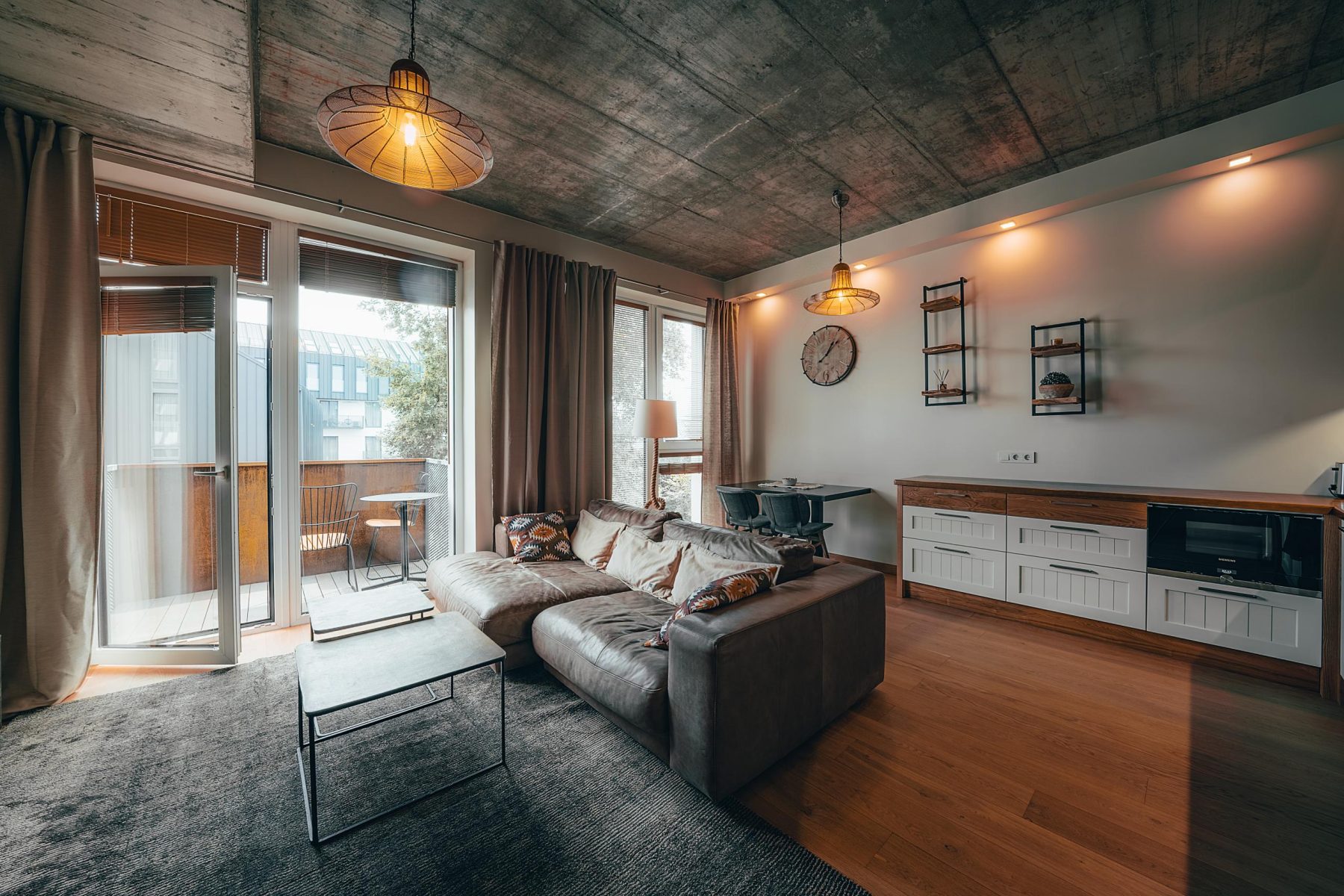 Moderni svetainė su sofa ir atvira virtuvės zona