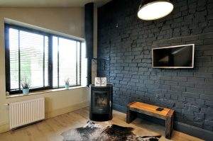 Industrinio stiliaus svetainė su sofa ir poilsio zona