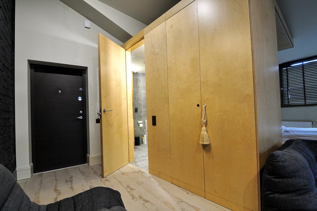 Lofto tipo apartamentų vidaus erdvės su natūralia mediena