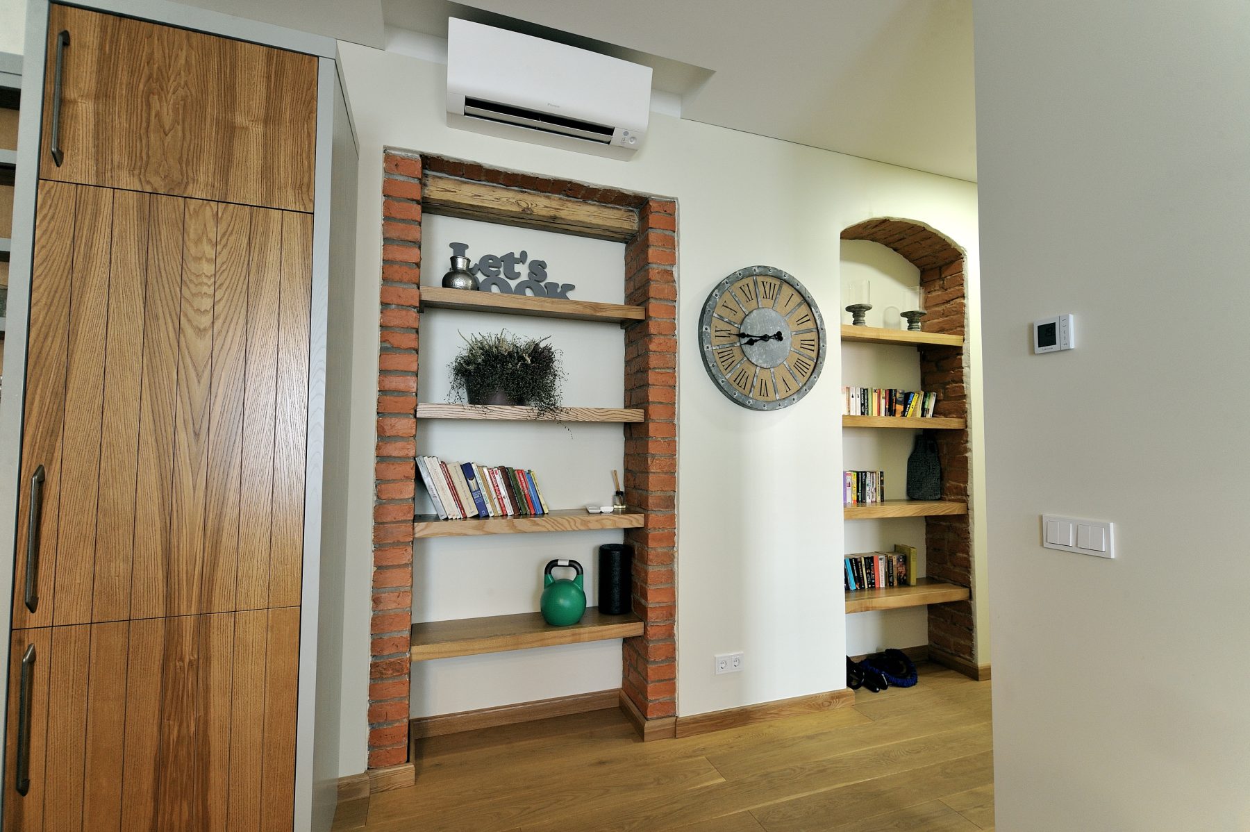 Modernus svetainės ir virtuvės interjeras su atvira erdve ir medinėmis grindimis