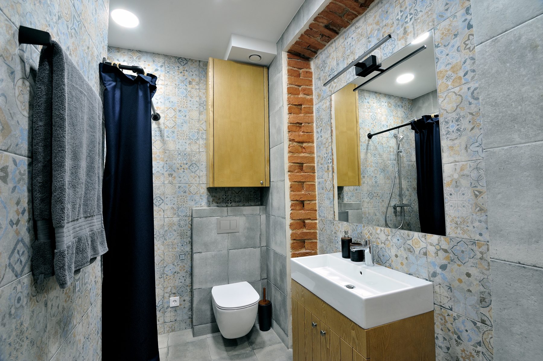 Modernus vonios kambarys su dušu, medinėmis spintelėmis ir dekoratyvinėmis plytelėmis