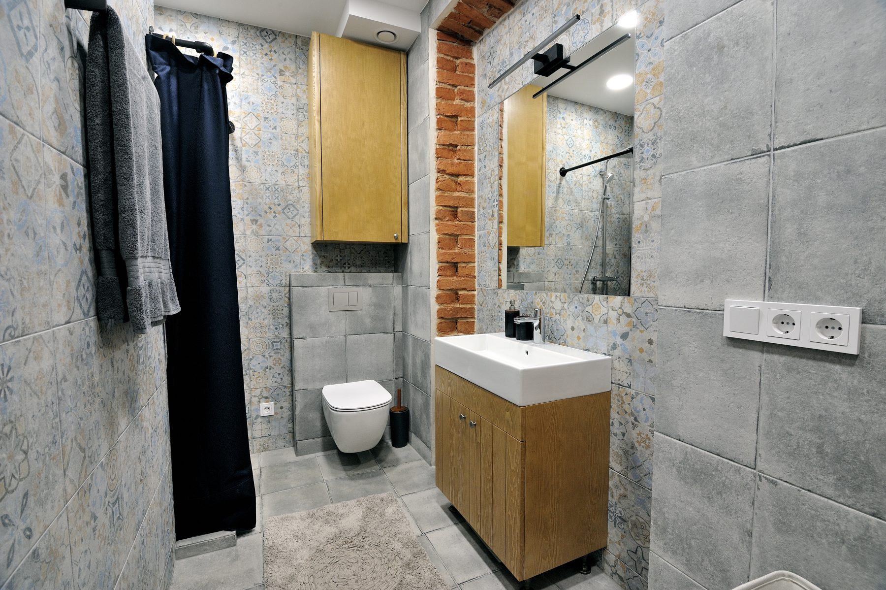 Modernus vonios kambarys su dušu, medinėmis spintelėmis ir dekoratyvinėmis plytelėmis