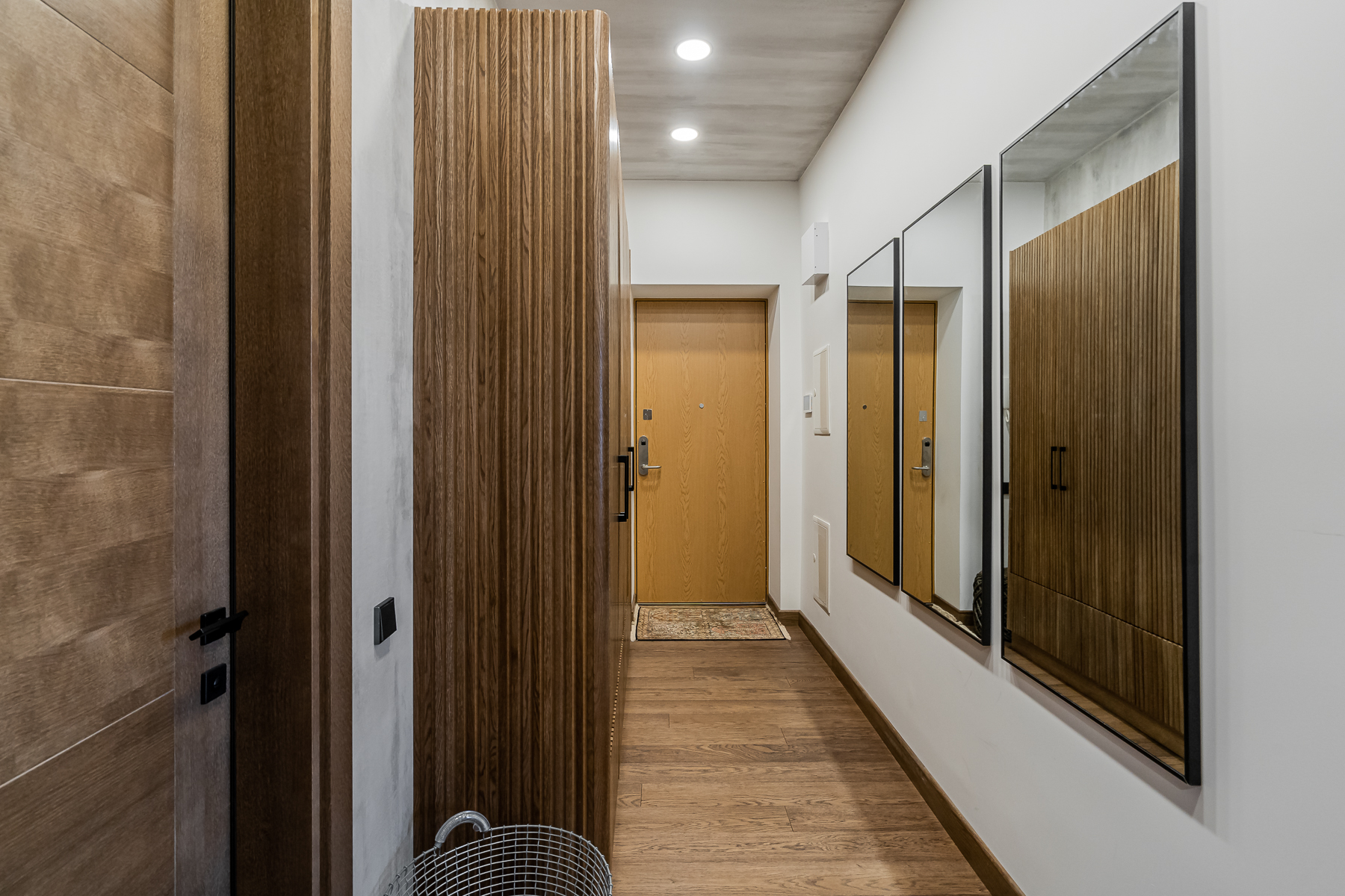 Modernus koridorius su švariomis linijomis ir natūraliais akcentais