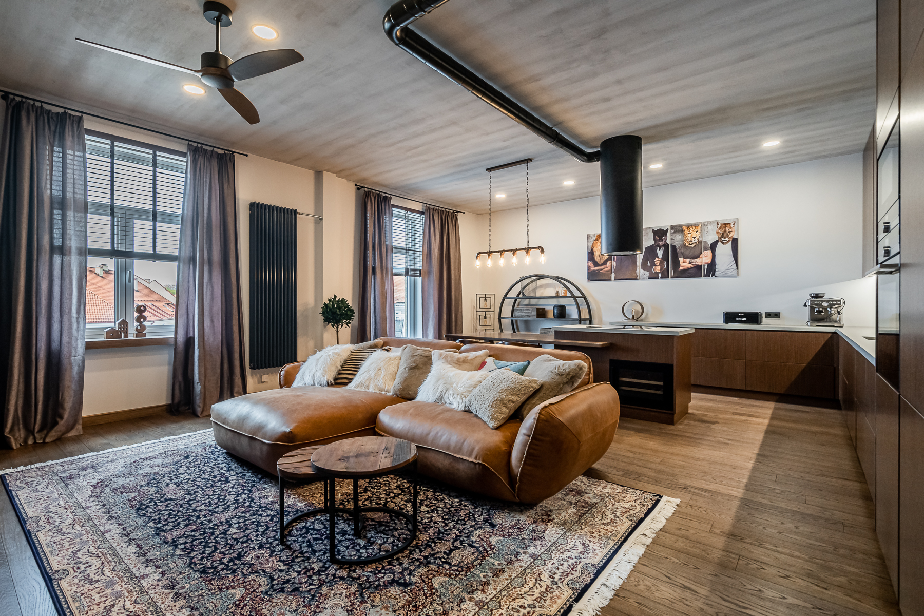 Šviesi svetainė su minkštais baldais ir senamiesčio vaizdu pro langus