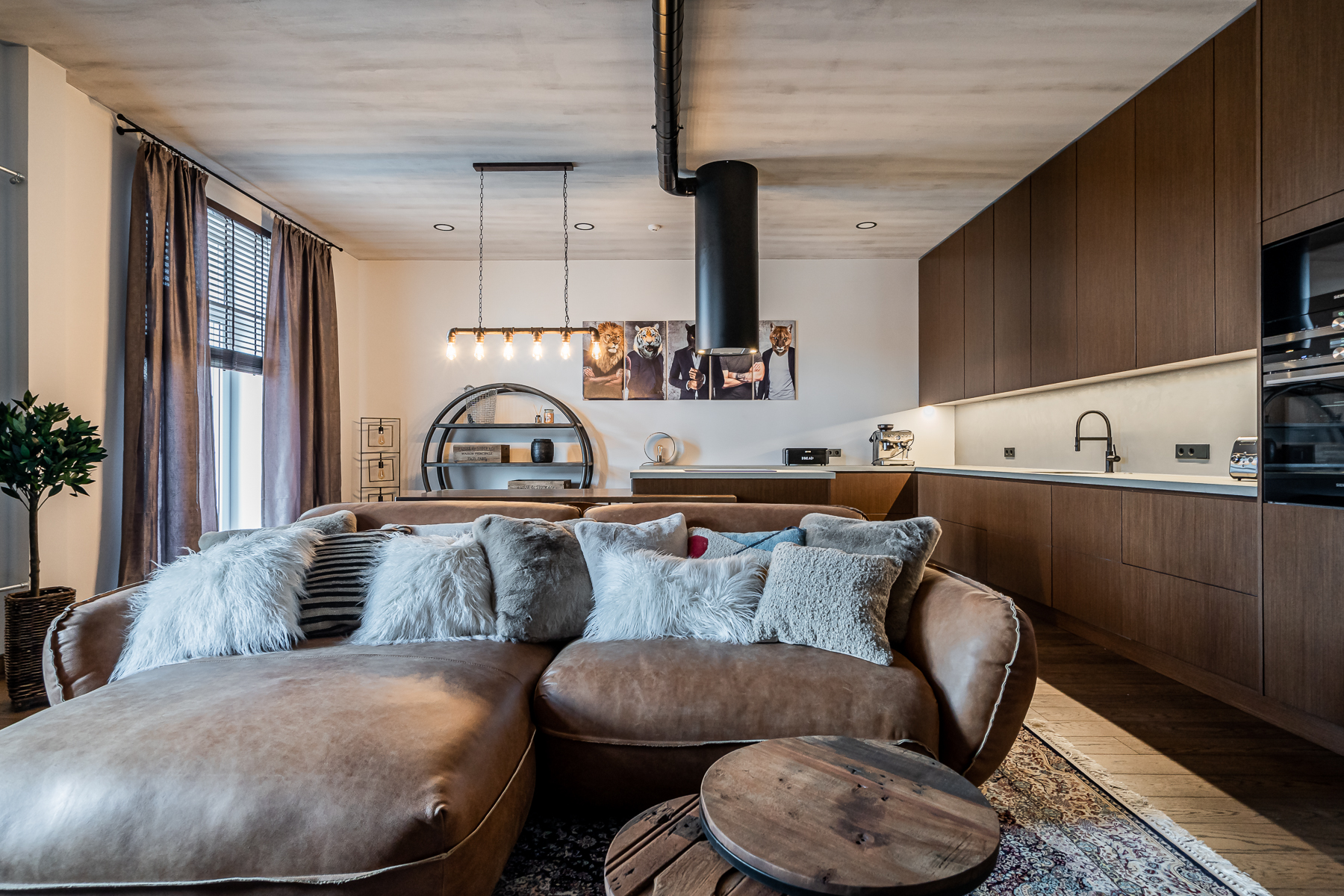 Šviesi svetainė su minkštais baldais ir senamiesčio vaizdu pro langus