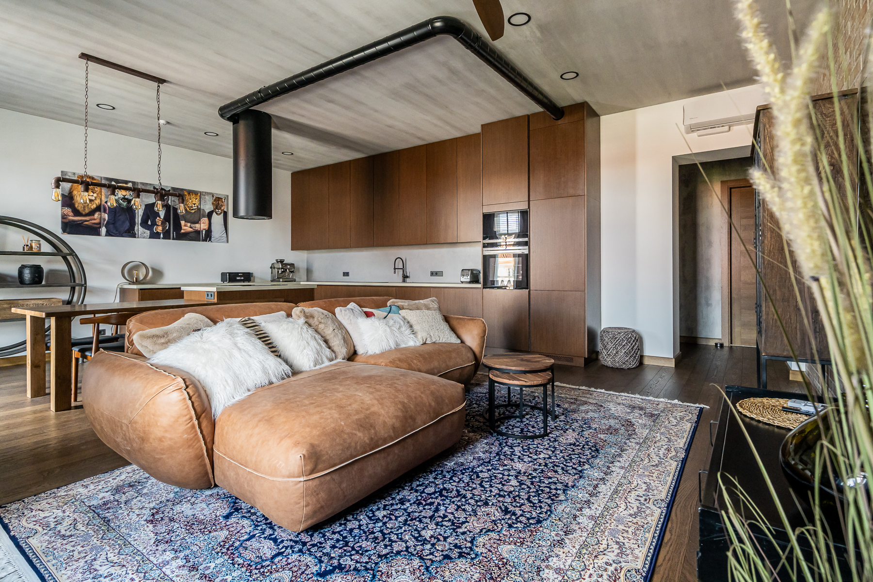 Šviesi svetainė su minkštais baldais ir senamiesčio vaizdu pro langus