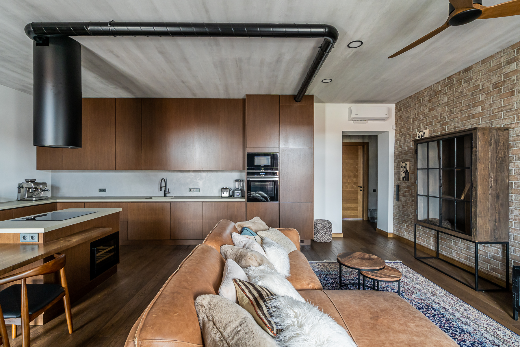 Šviesi svetainė su minkštais baldais ir senamiesčio vaizdu pro langus