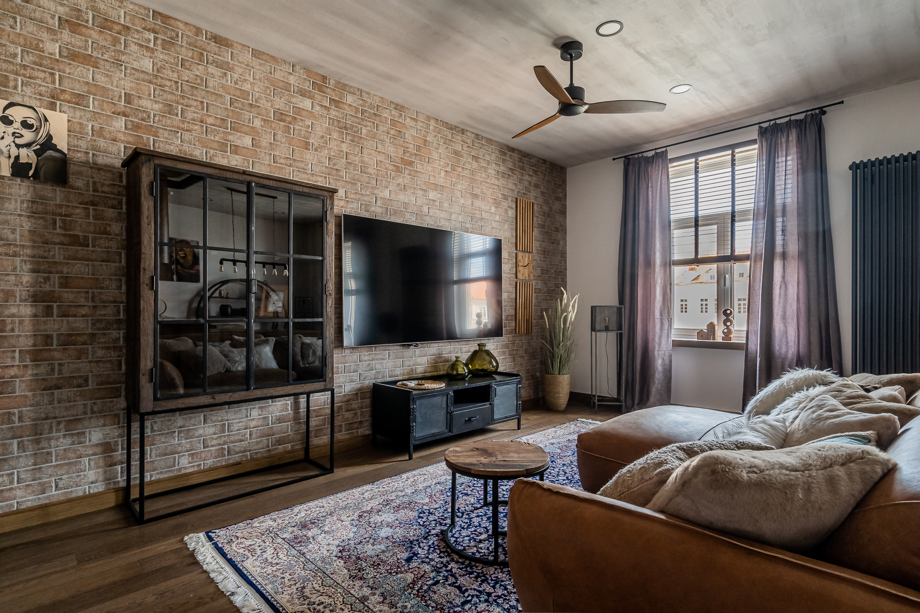 Šviesi svetainė su minkštais baldais ir senamiesčio vaizdu pro langus