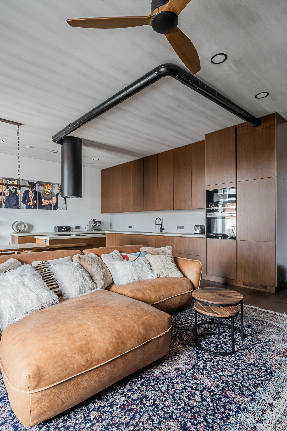 Šviesi svetainė su minkštais baldais ir senamiesčio vaizdu pro langus