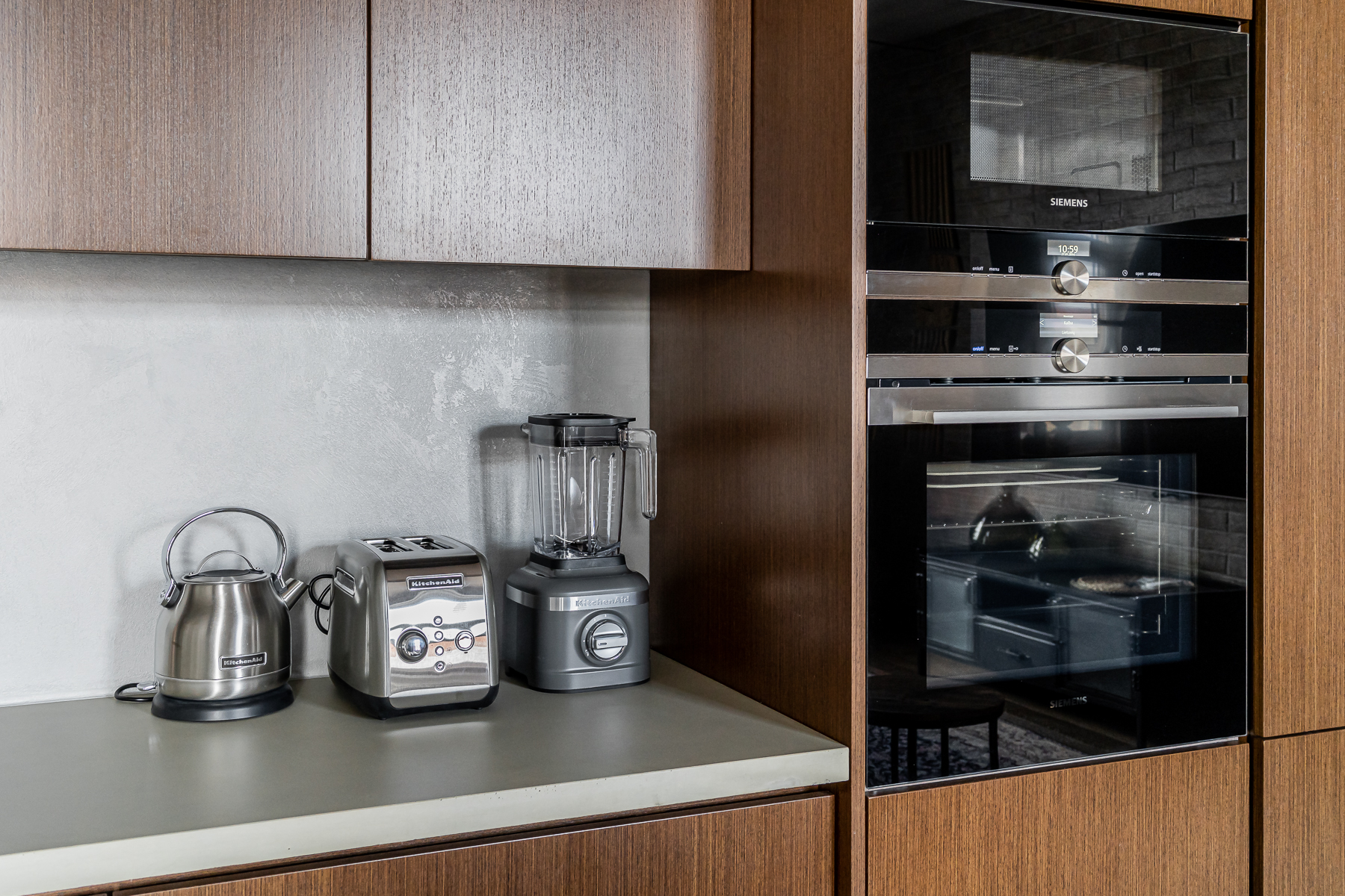 Šiuolaikiška virtuvė su integruota buitine technika ir medžio apdaila