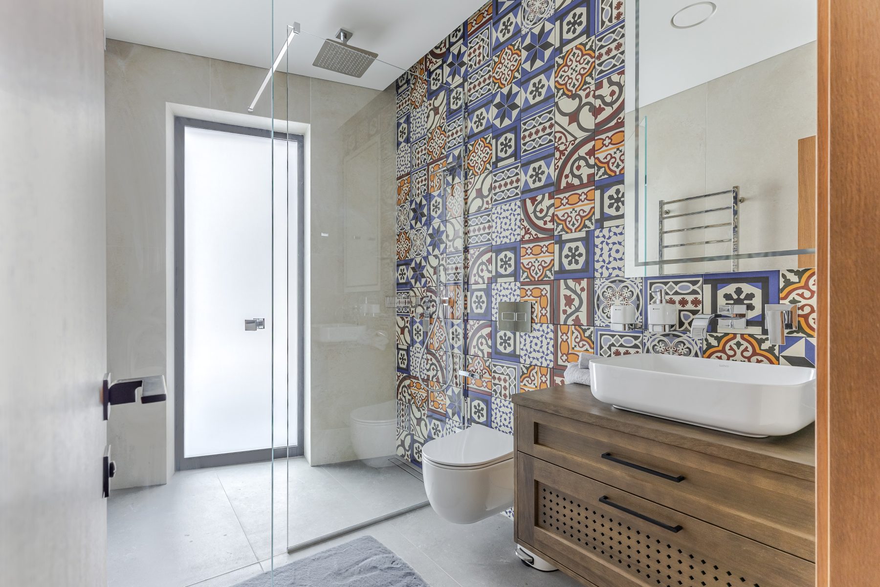 Vonios kambarys su šiuolaikine santechnika ir raštuotomis plytelėmis