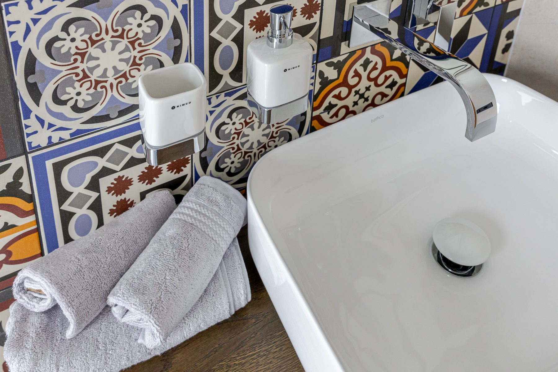 Vonios kambarys su šiuolaikine santechnika ir raštuotomis plytelėmis