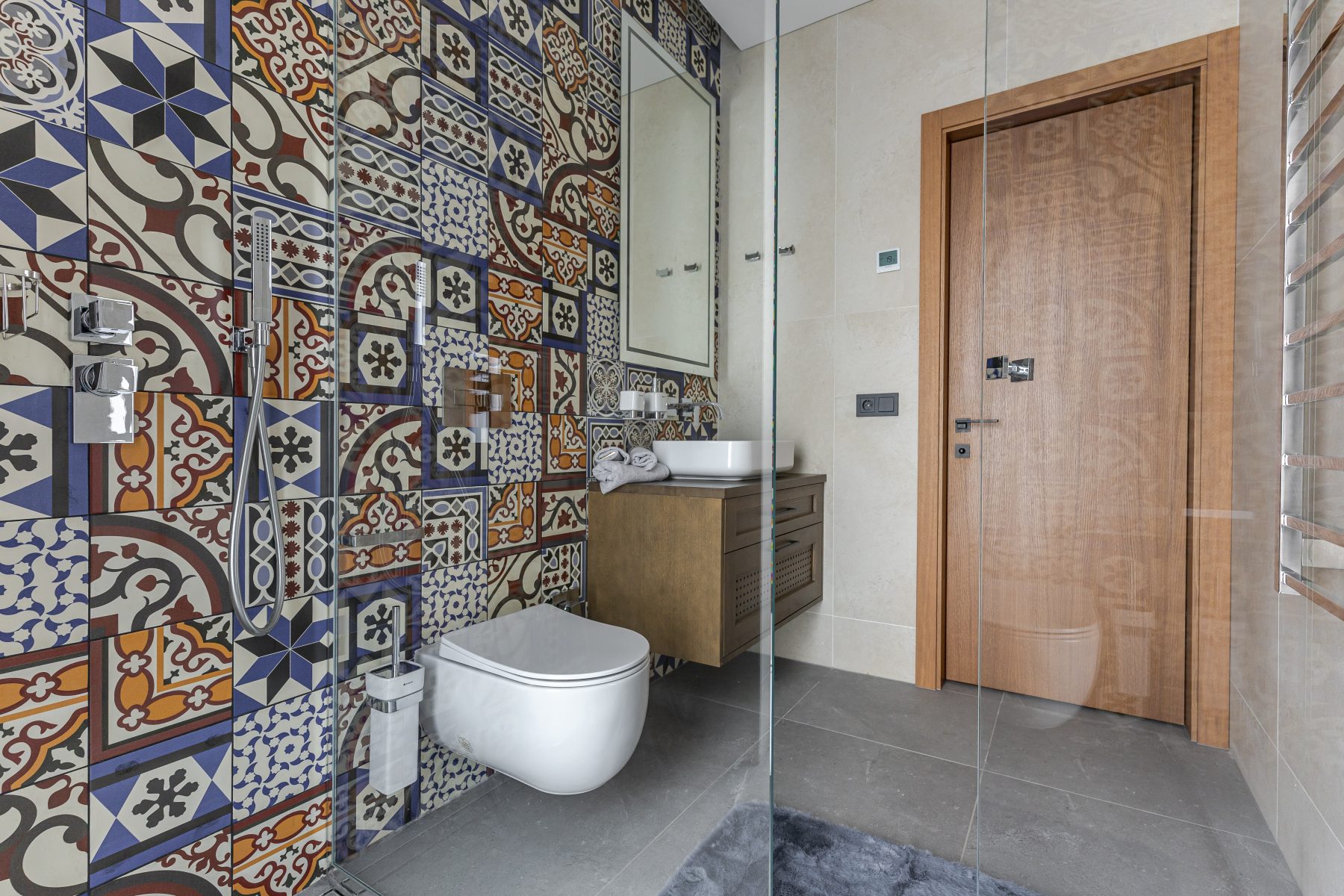 Vonios kambarys su šiuolaikine santechnika ir raštuotomis plytelėmis