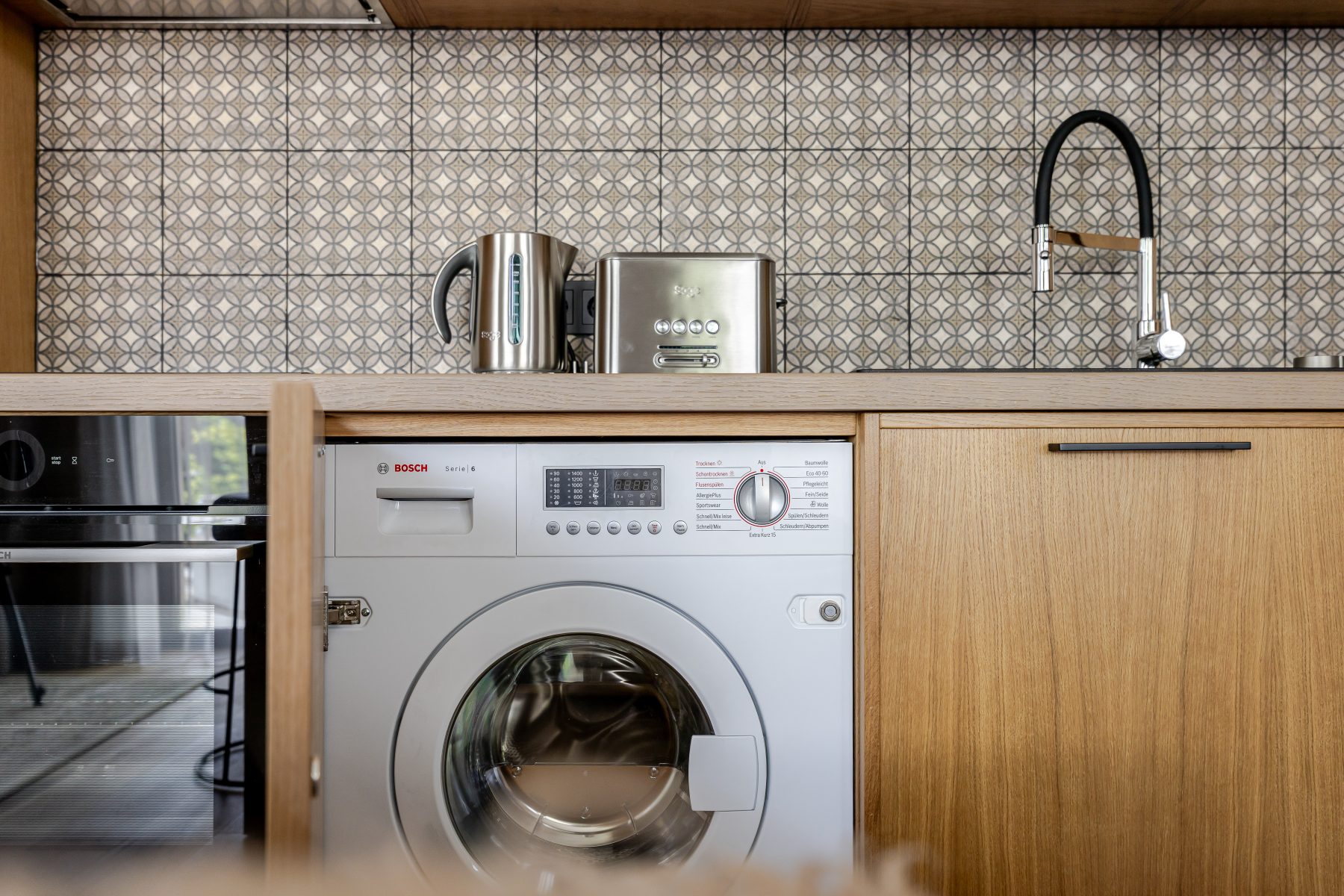 Virtuvė su valgomojo stalu ir integruota buitine technika