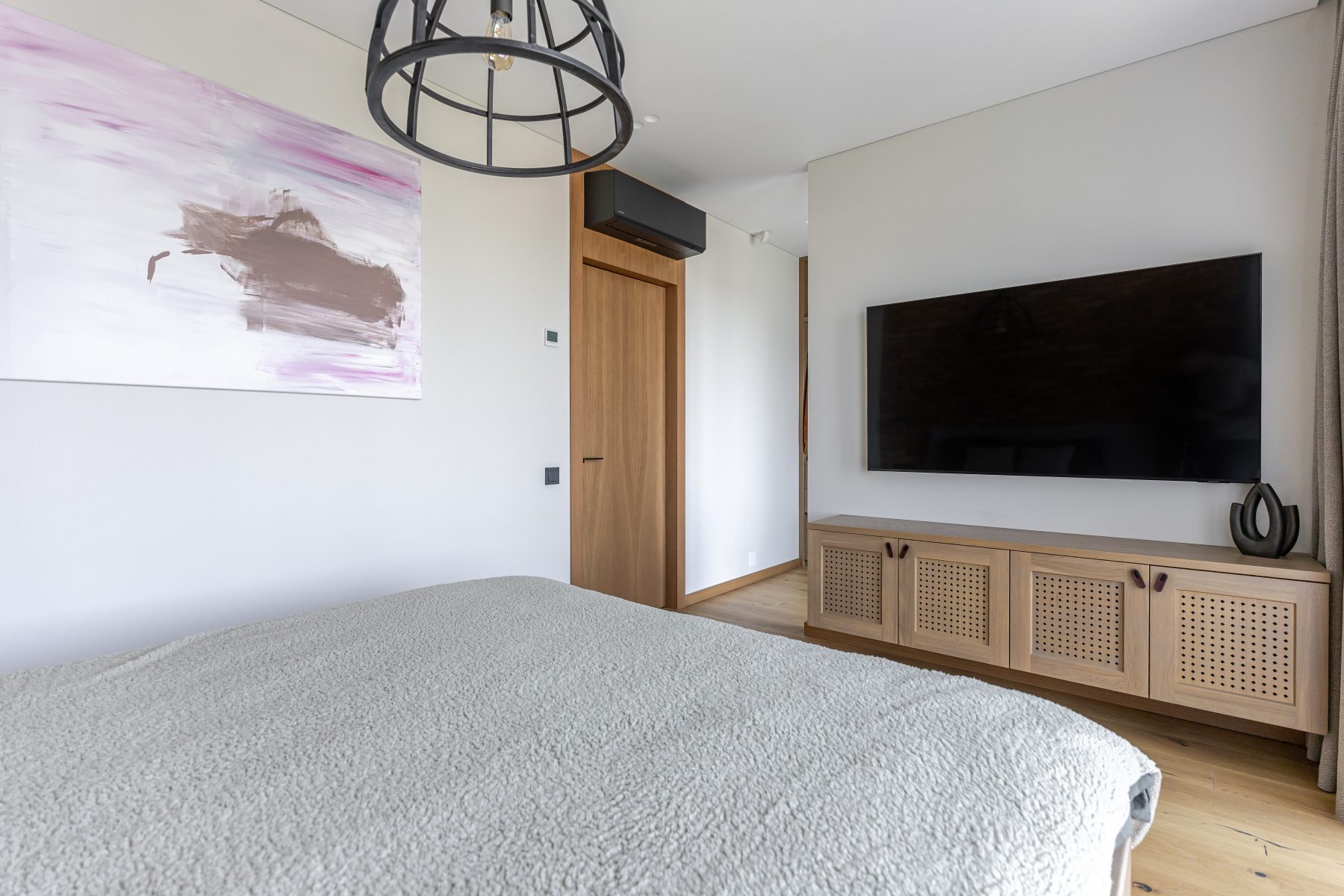 Miegamasis su natūralių plytų siena ir dideliais langais