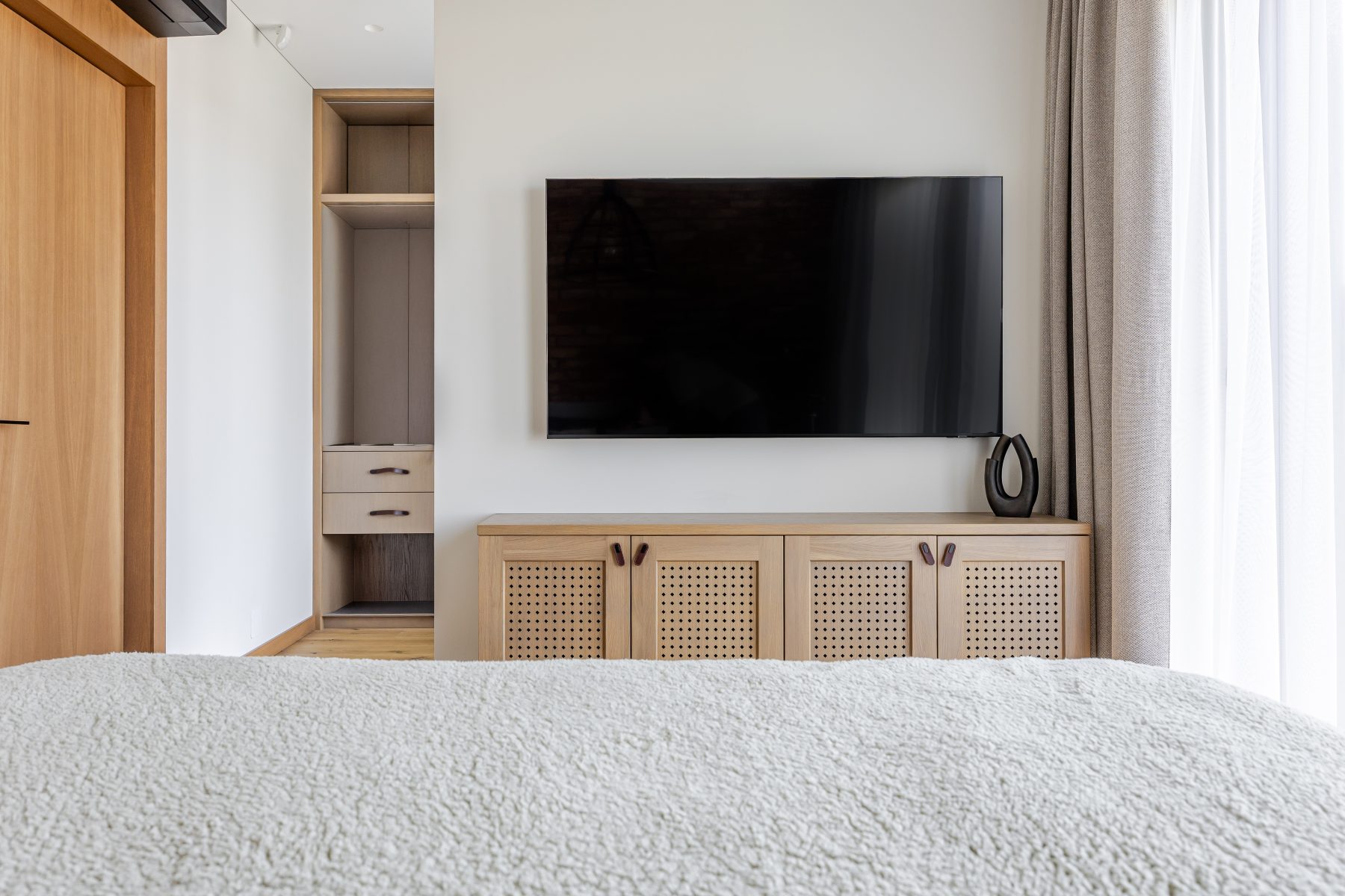 Miegamasis su natūralių plytų siena ir dideliais langais