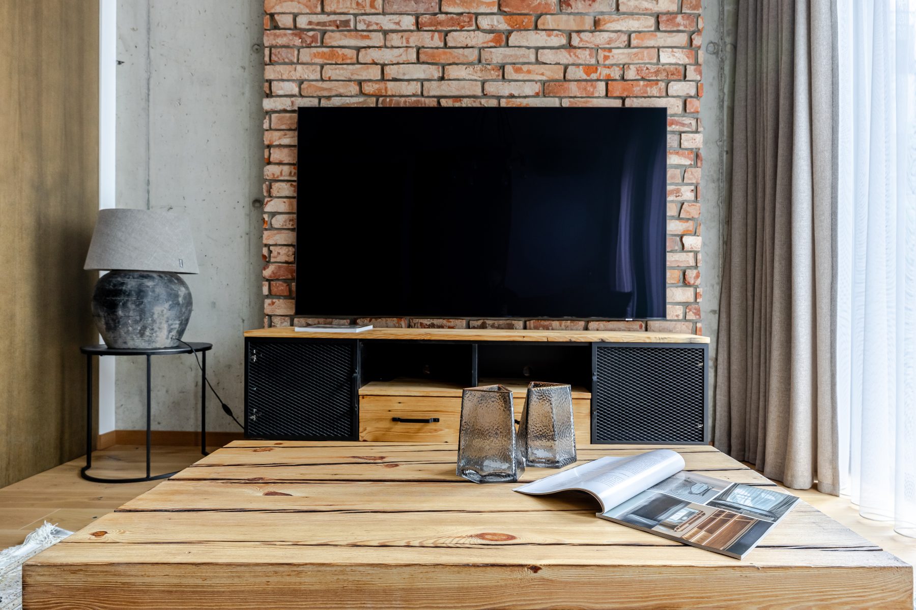 Moderni svetainė su natūralaus medžio detalėmis ir dizaino akcentais