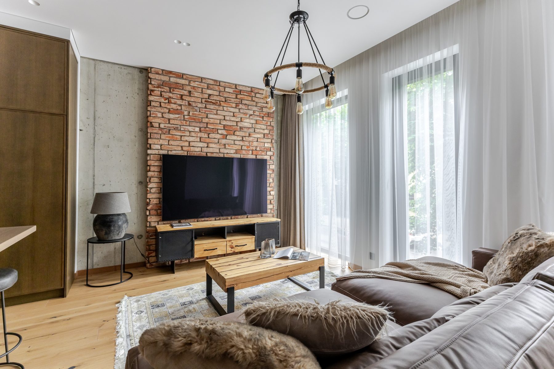 Moderni svetainė su natūralaus medžio detalėmis ir dizaino akcentais