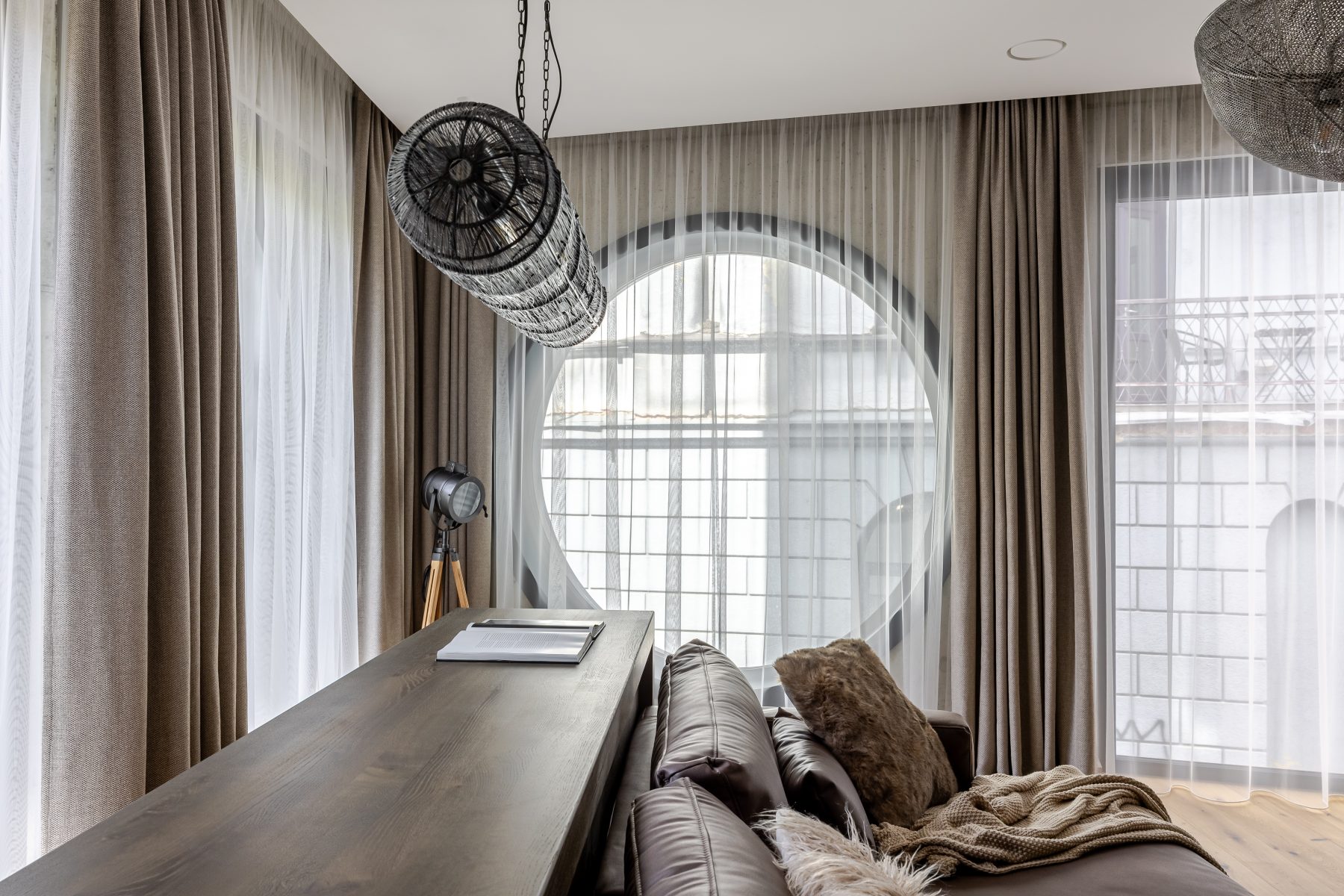 Šviesi moderni svetainė su dideliais langais ir natūralaus medžio detalėmis