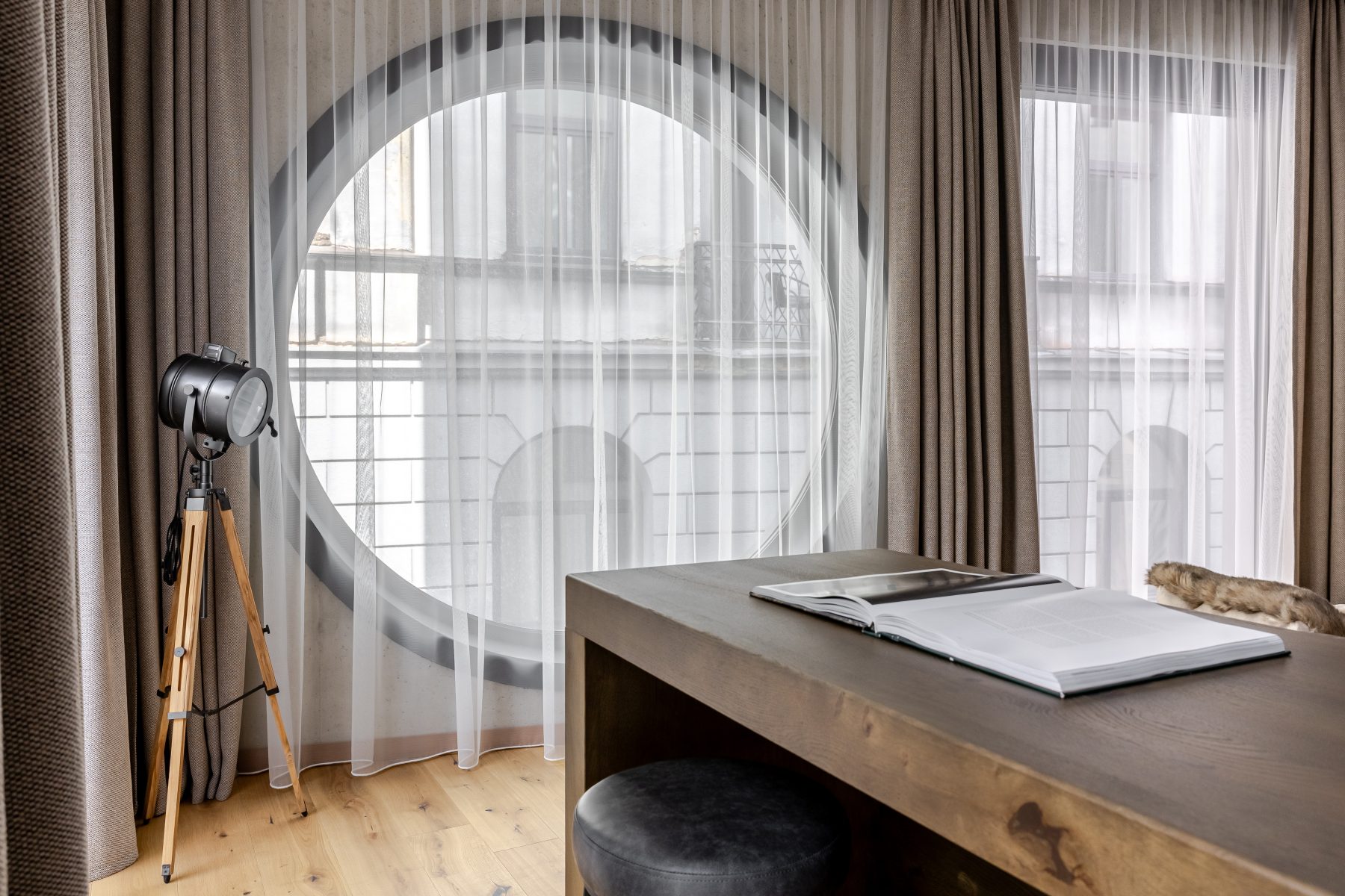 Šviesi moderni svetainė su dideliais langais ir natūralaus medžio detalėmis