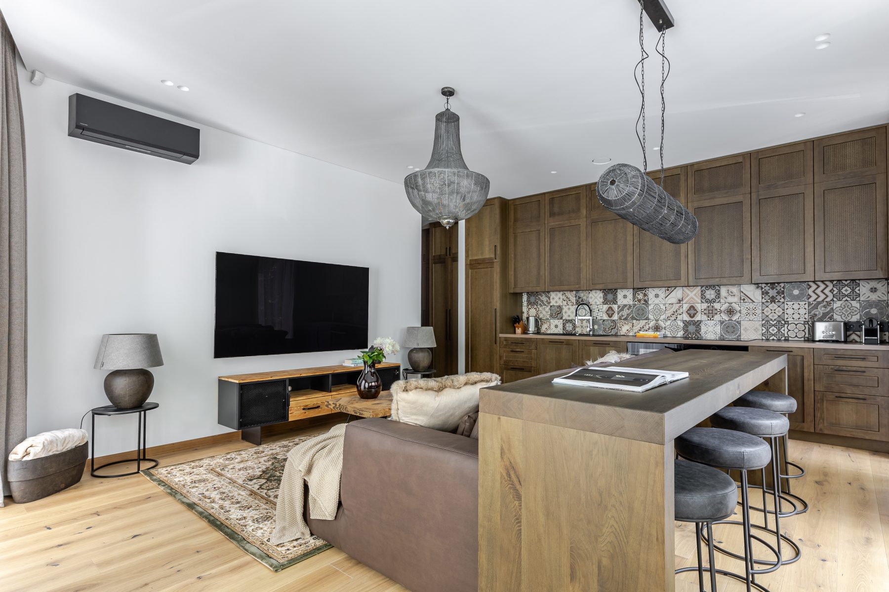 Šviesi moderni svetainė su dideliais langais ir natūralaus medžio detalėmis