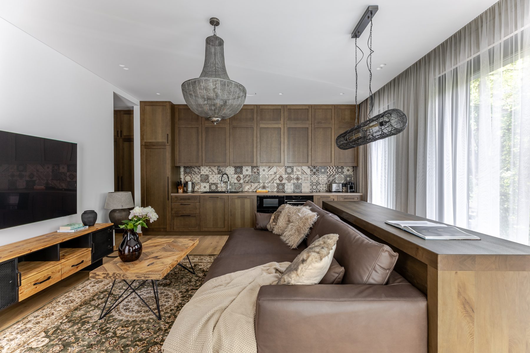 Šviesi moderni svetainė su dideliais langais ir natūralaus medžio detalėmis