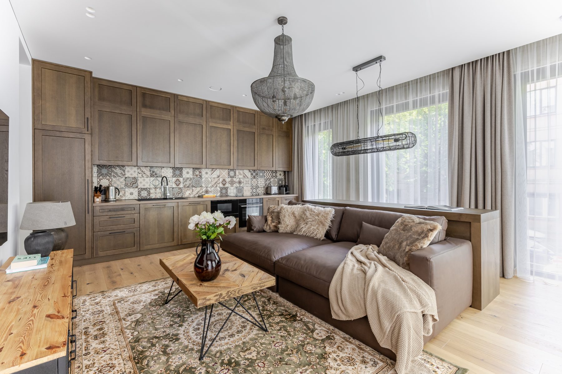 Šviesi moderni svetainė su dideliais langais ir natūralaus medžio detalėmis