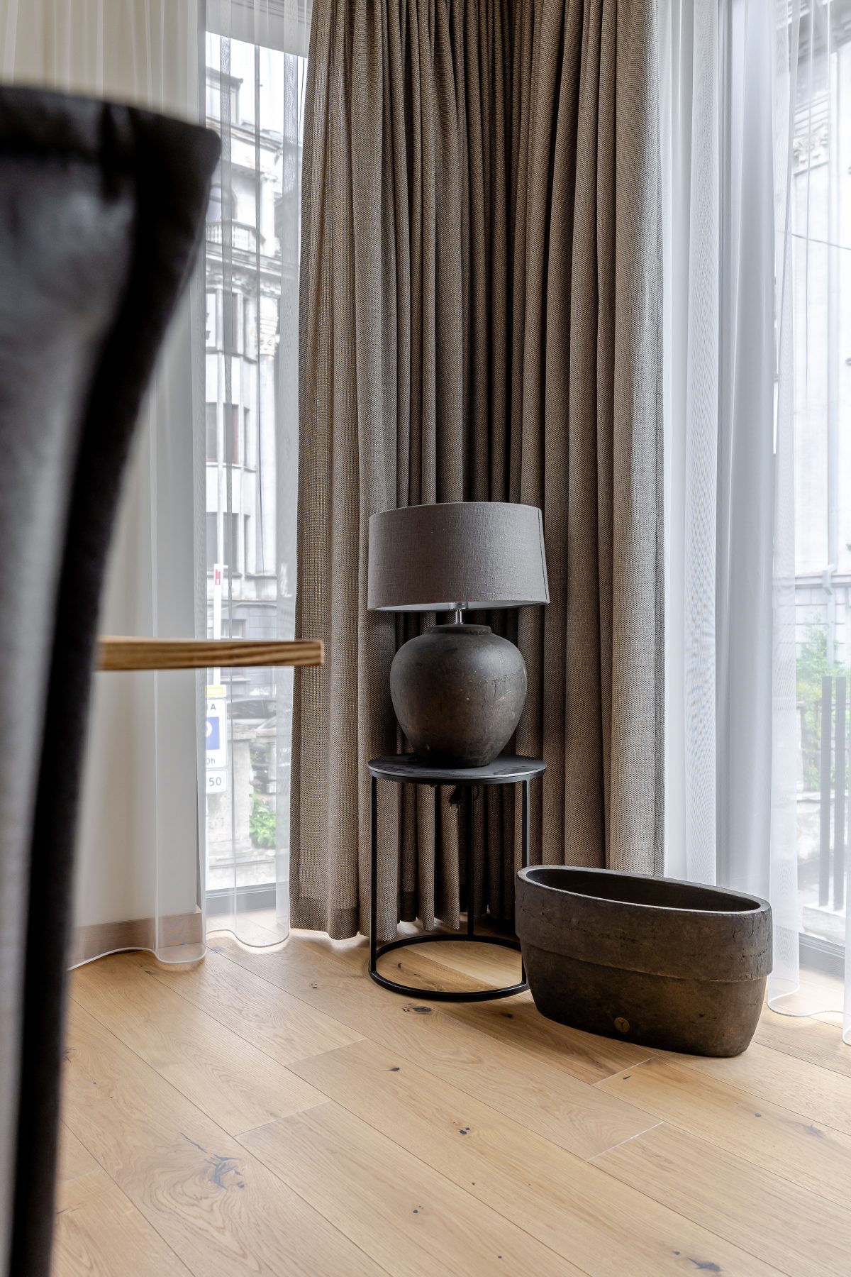 Erdvi svetainė su minkštais baldais, natūralaus medžio detalėmis ir dideliais langais