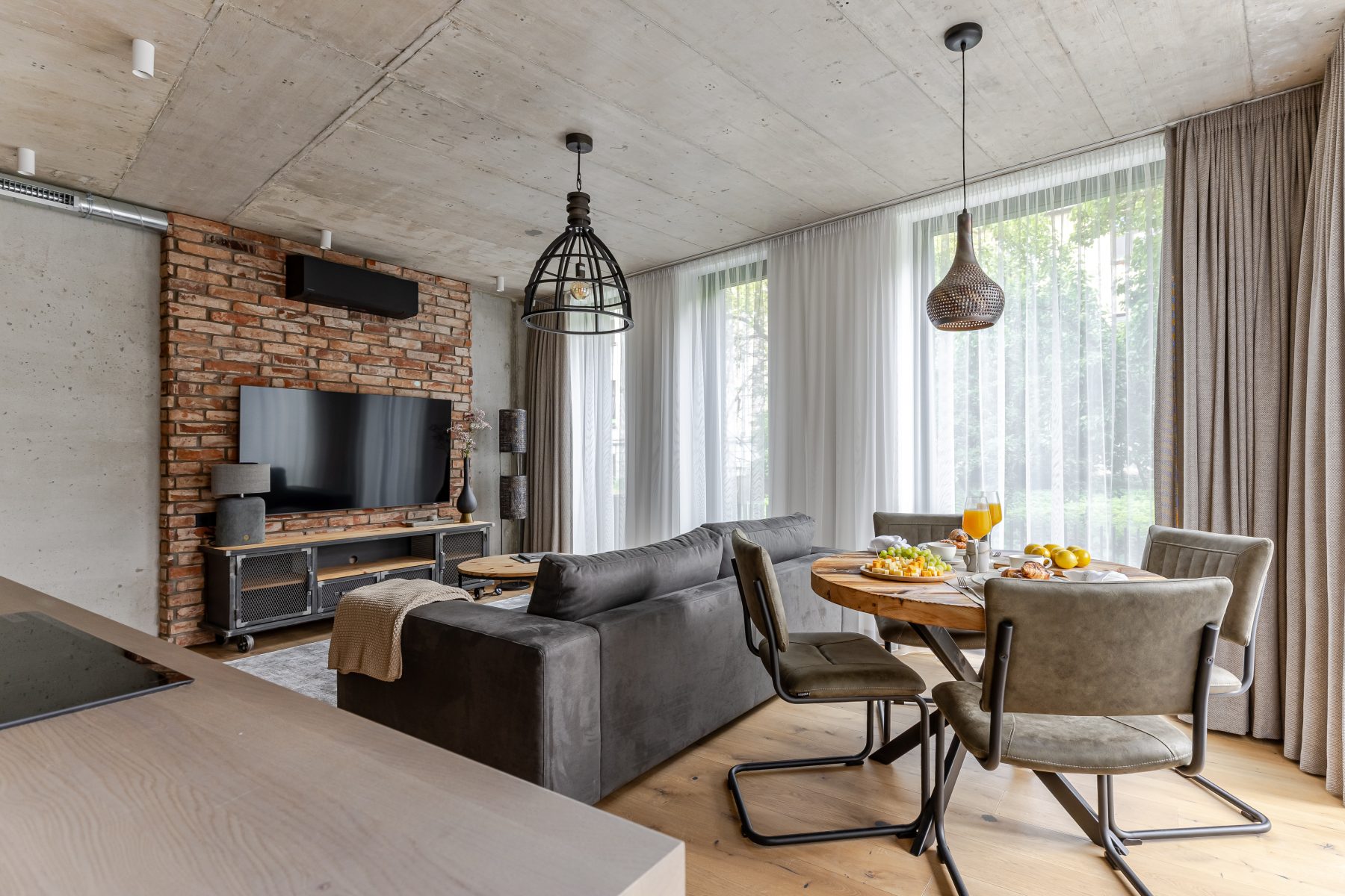 Moderni svetainė su dizaino baldais ir dideliais langais