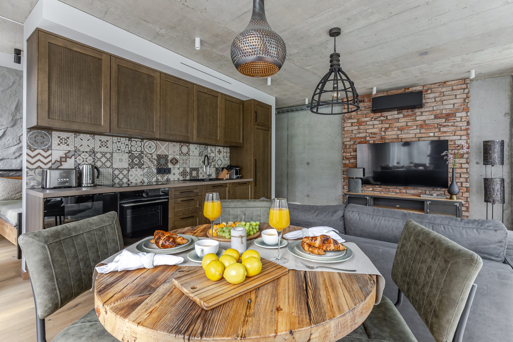 Moderni svetainė su dizaino baldais ir dideliais langais